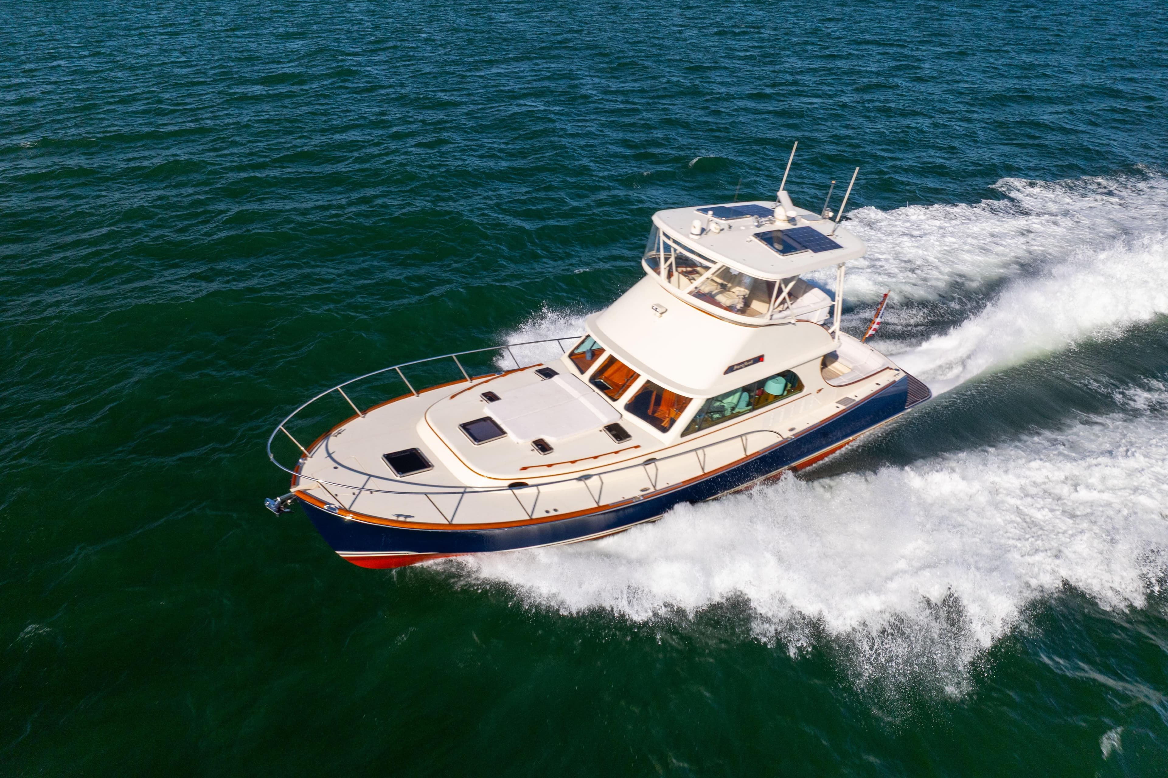 2014 Hinckley Talaria 48 Flybridge cruising on open water, showcasing elegant design.