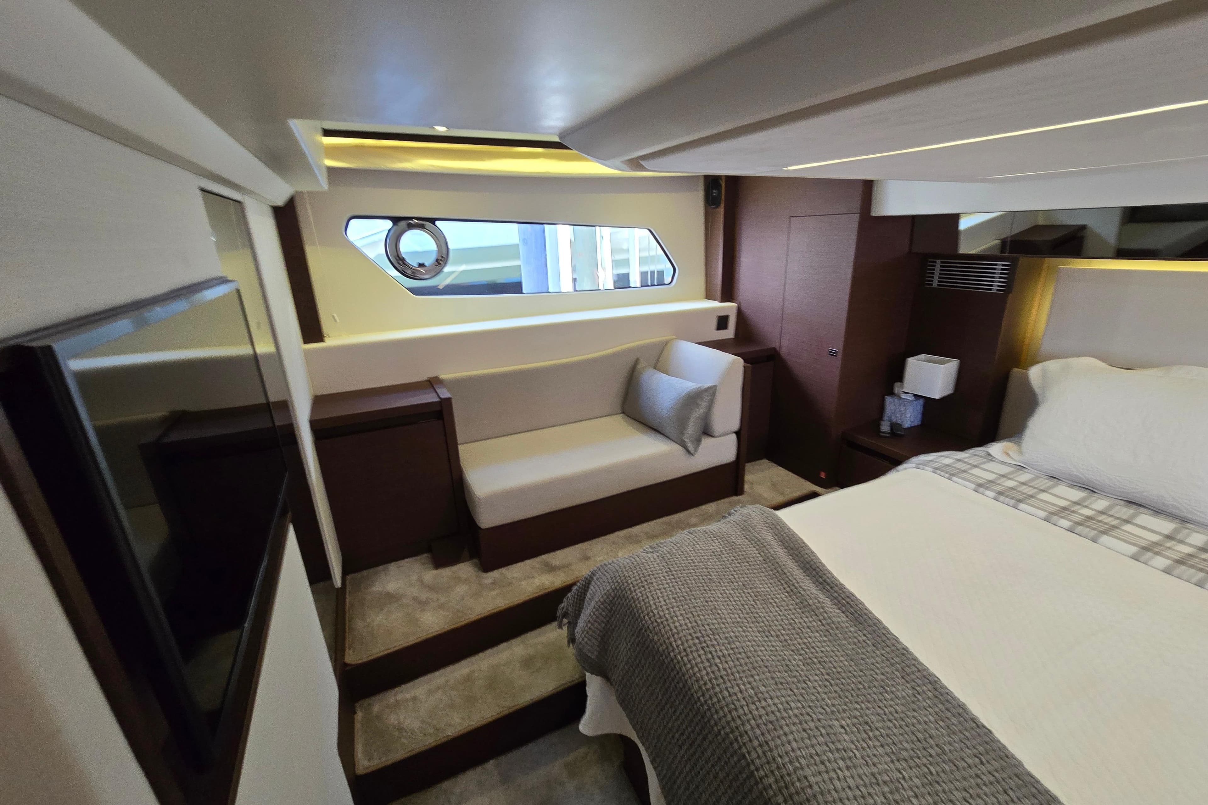 Luxurious interior of a 2018 Prestige 460 yacht, featuring a cozy bedroom and seating area.