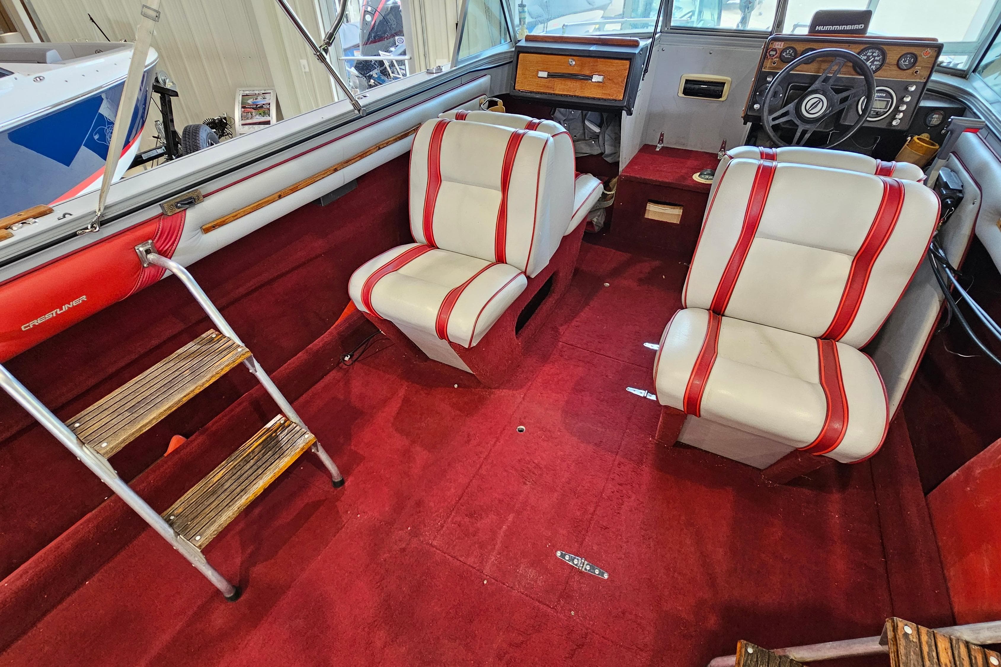 1988 Crestliner 2281 boat interior with red carpet, white seats, and wooden accents.