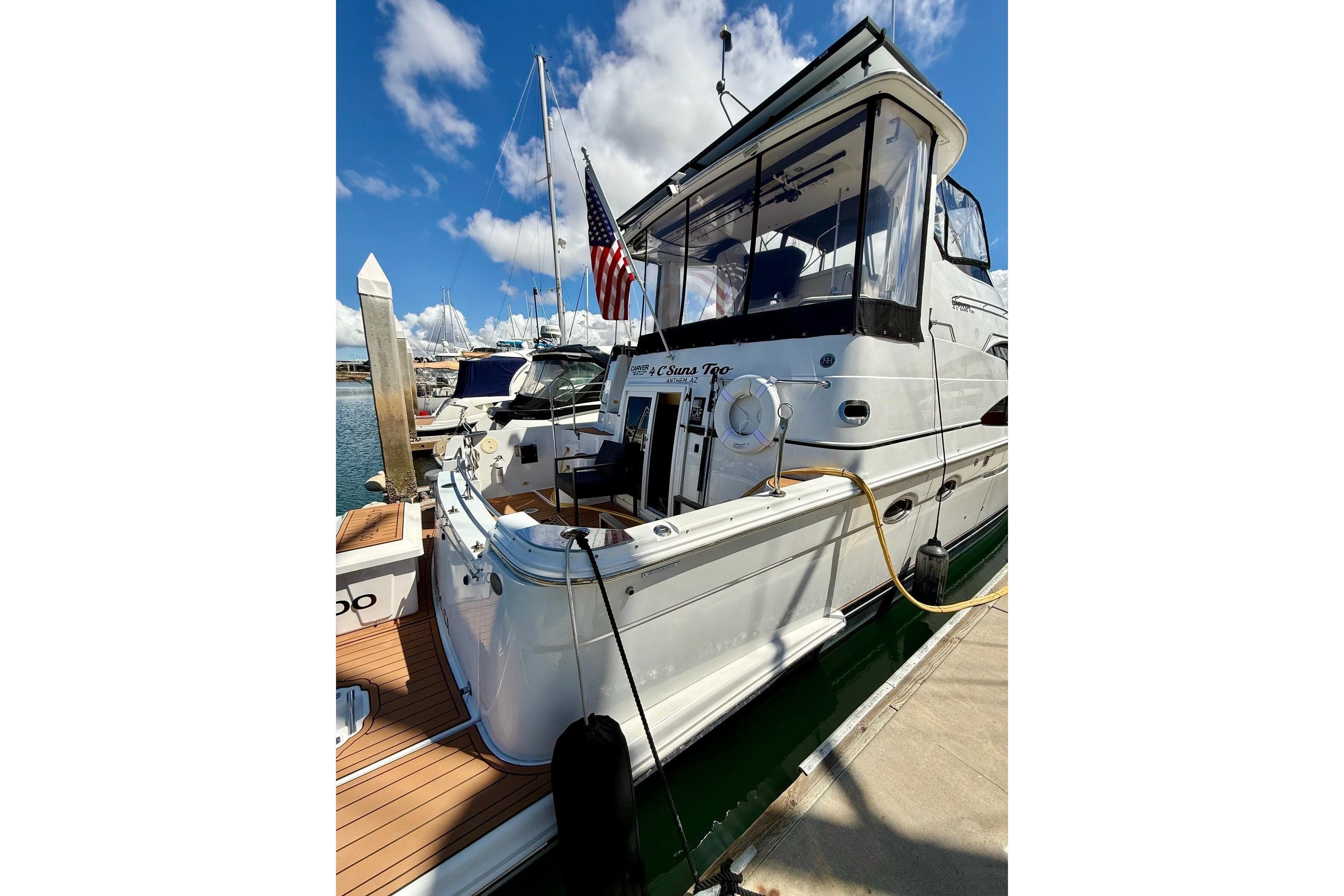 2001 Carver 444 Cockpit Motor Yacht docked, featuring sleek design and American flag.