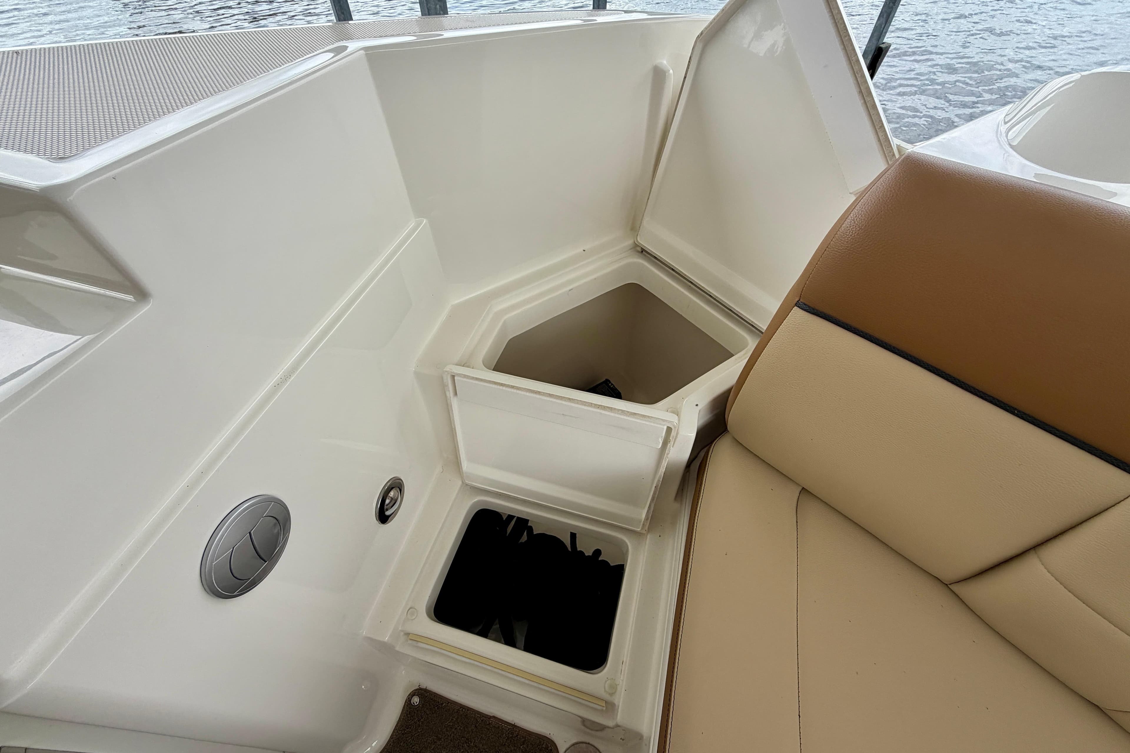 2015 Sea Ray SLX 350 boat interior with open storage compartment and tan seating.