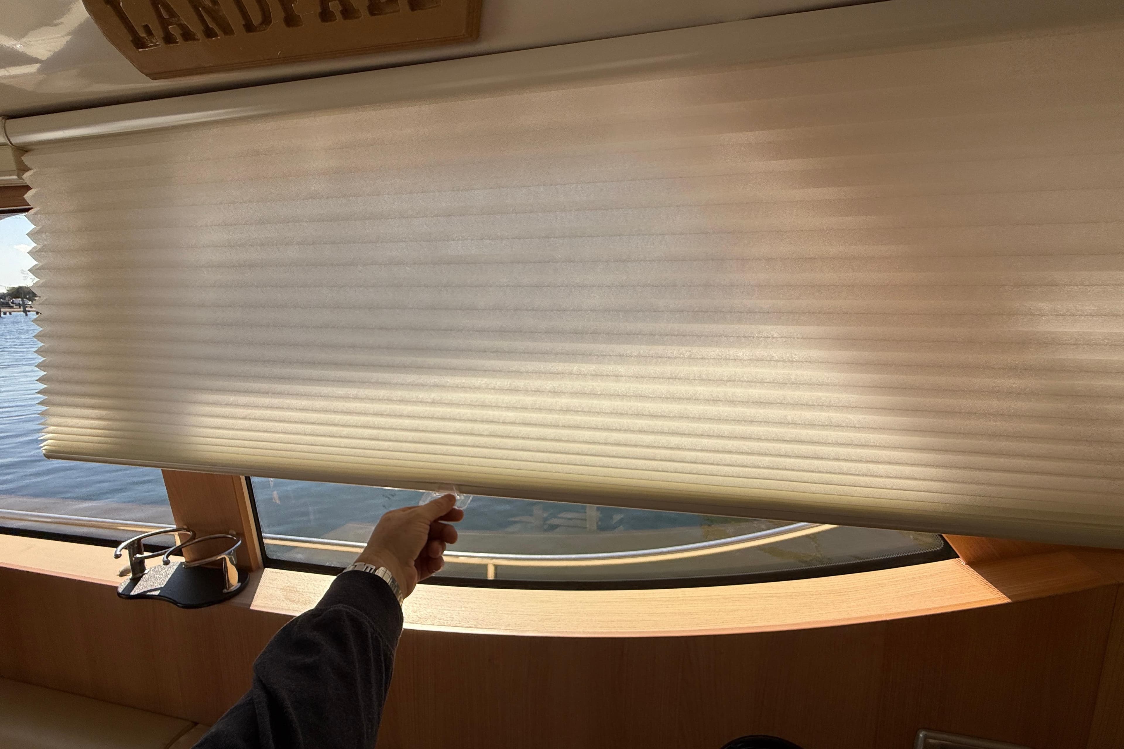 Person adjusting window blind on 2013 Greenline 33 yacht interior.