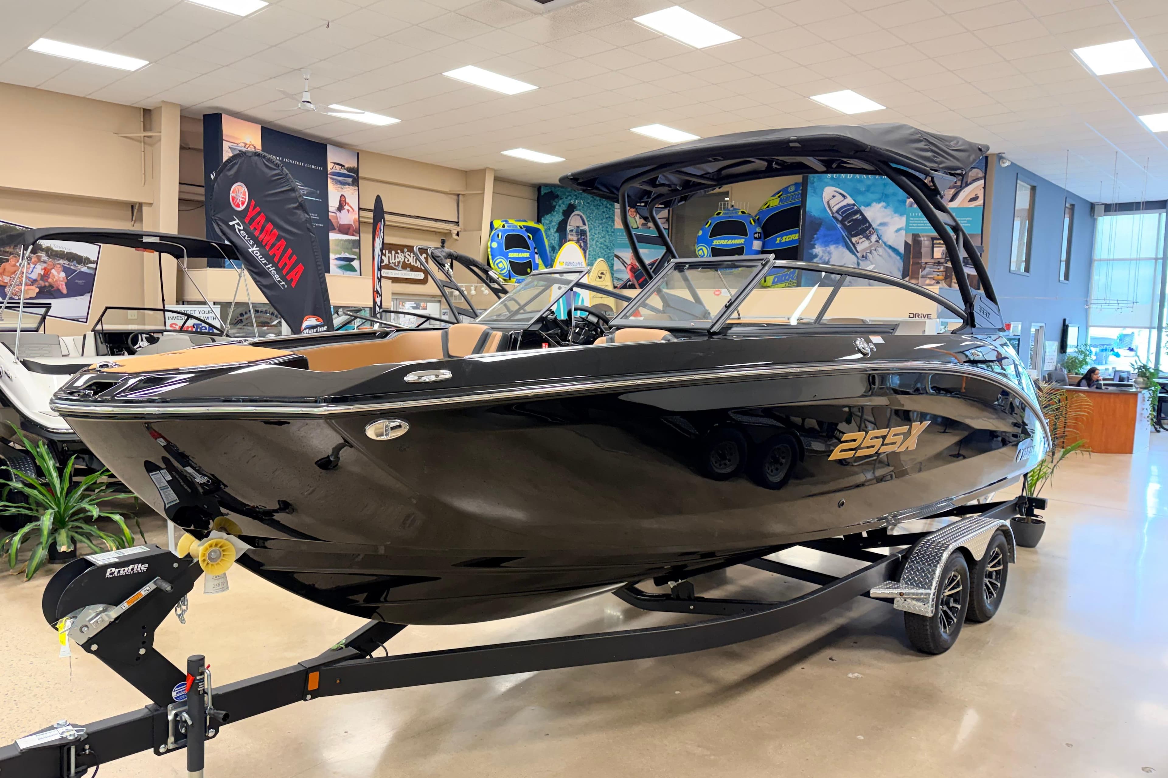 2026 Yamaha Boats 255XD displayed in showroom, sleek black design on trailer.