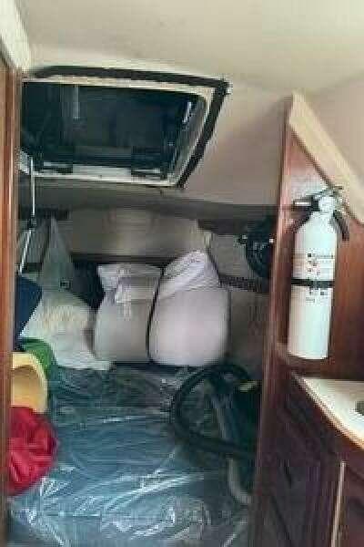 Interior cabin of a 1988 Catalina 30 sailboat with cushions and fire extinguisher.