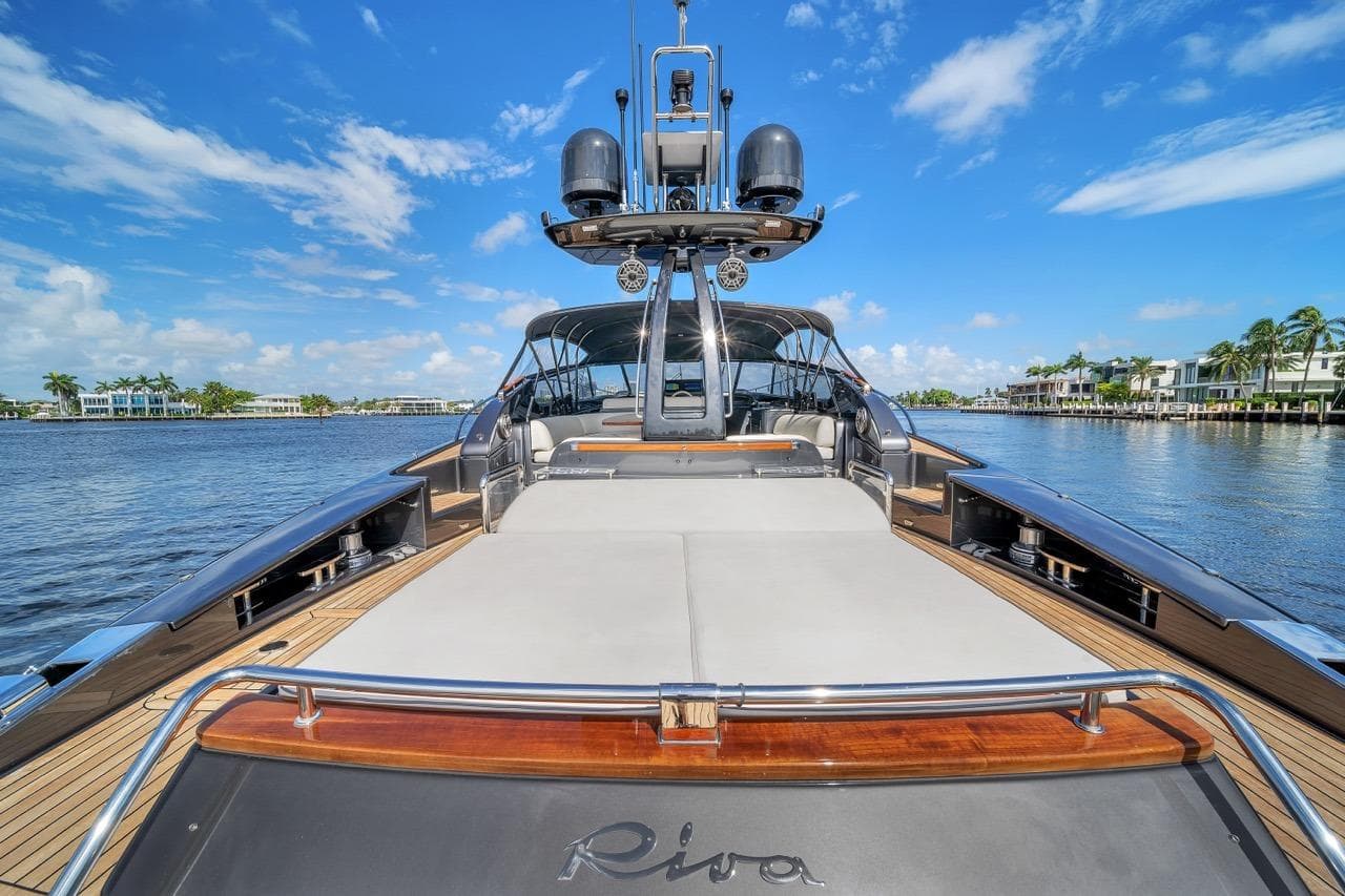 Luxurious 2015 Riva 63 yacht on a sunny day, featuring sleek design and spacious deck.