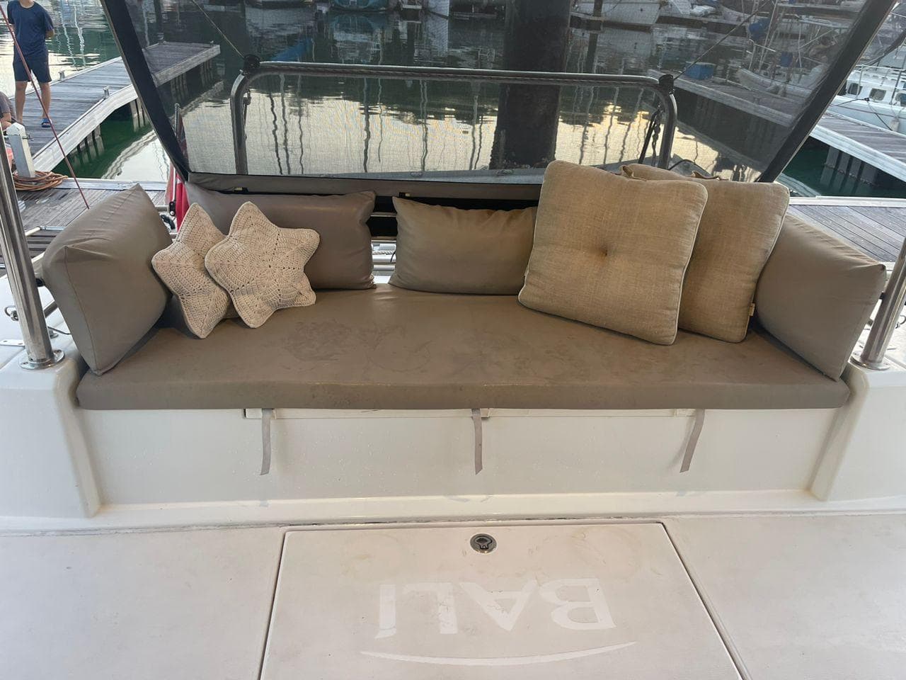 Cozy seating area on 2018 Catana Bali 4.1 catamaran with cushions and star-shaped pillows.