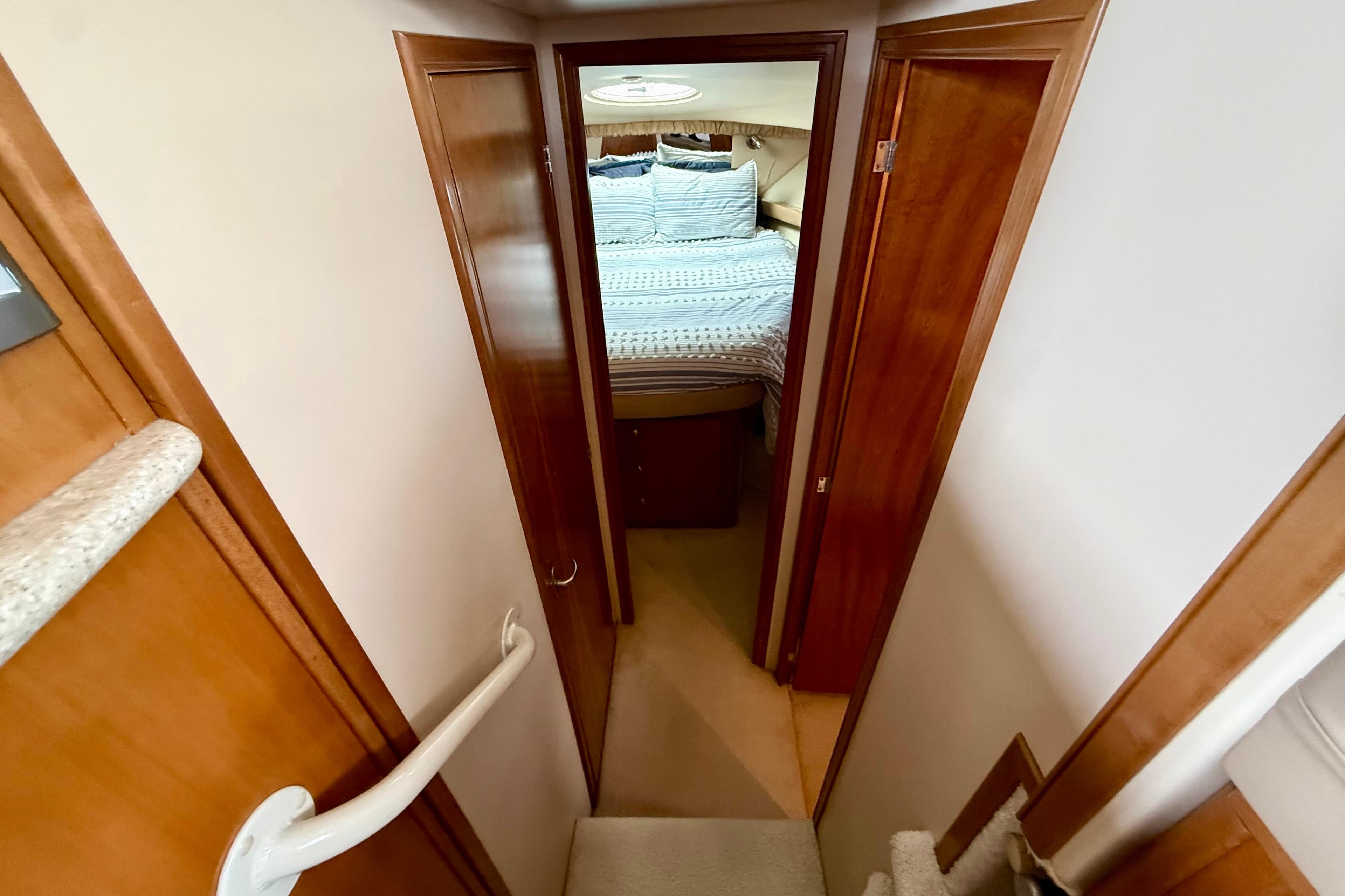 Interior view of 2003 Meridian 381 Sedan yacht bedroom with wooden doors and cozy bedding.