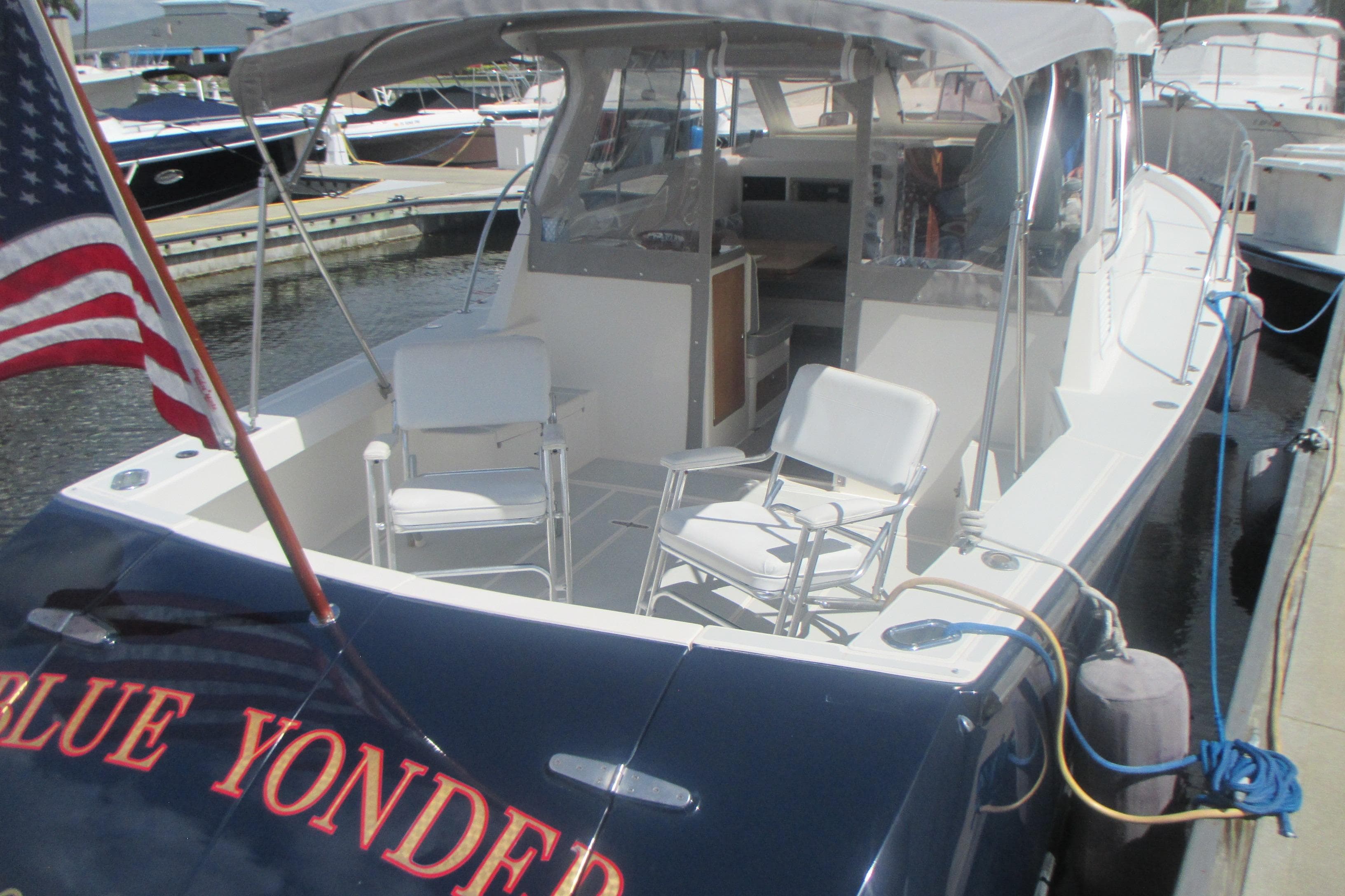 2005 True North 33 boat docked, featuring seating and American flag.