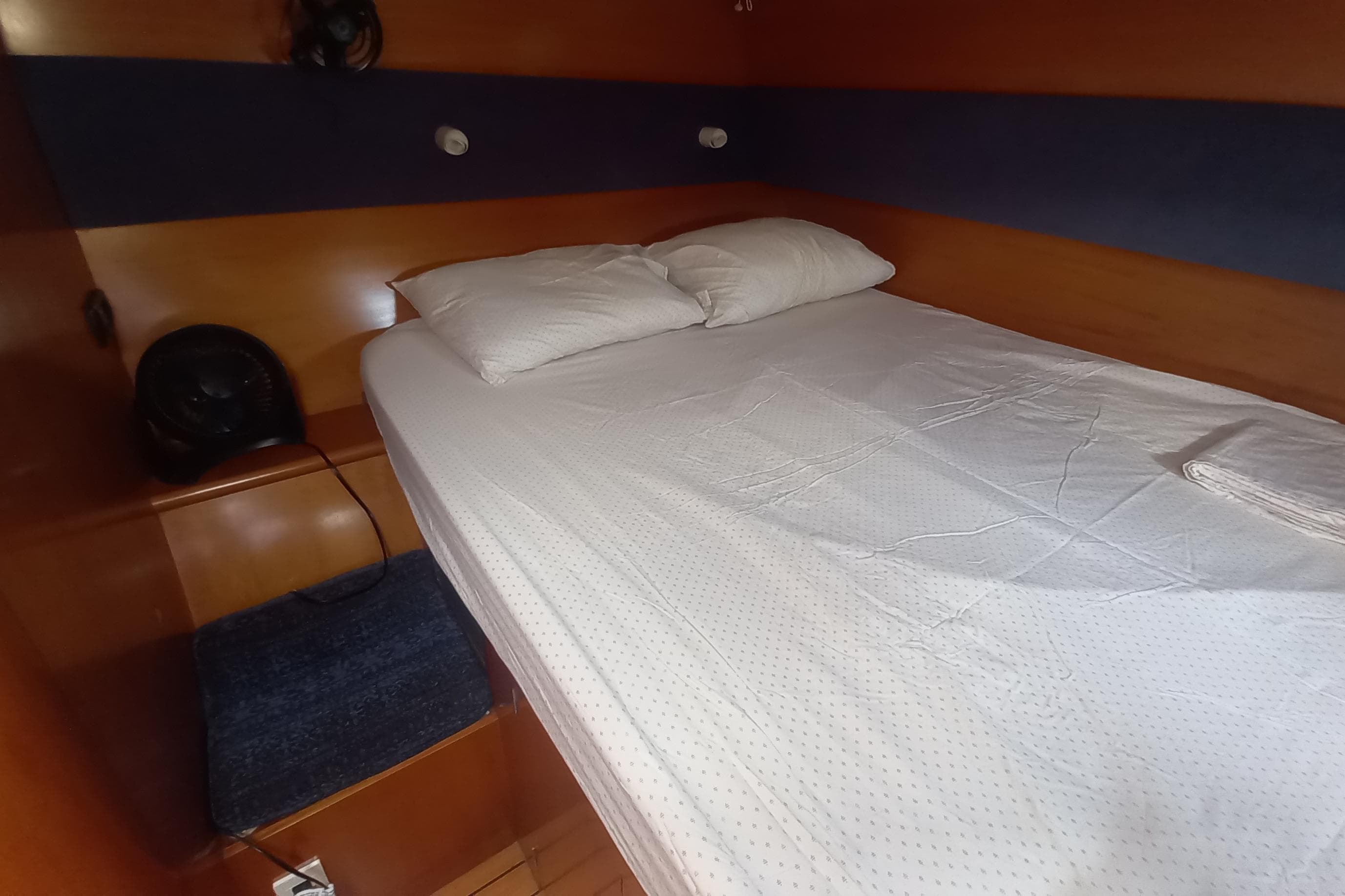 Cozy cabin interior of 2002 Lagoon 470 yacht with bed and wooden finish.