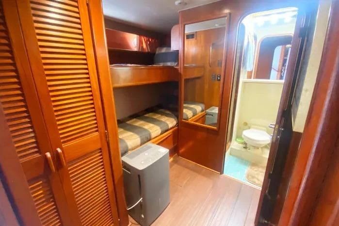 1990 Viking Motor Yacht interior with bunk beds, wooden cabinetry, and bathroom.