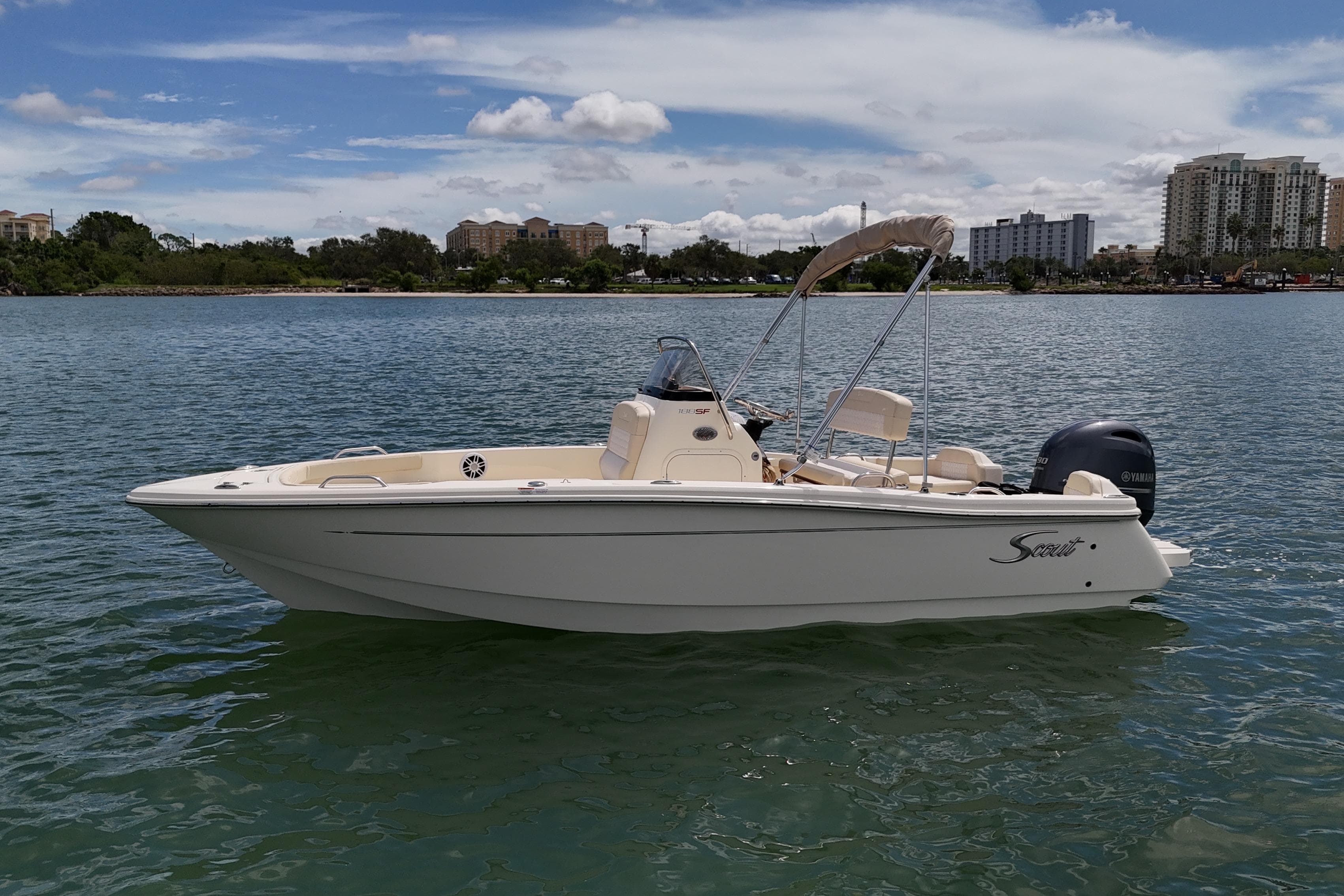 2026 Scout 188 Sportfish boat on calm water with cityscape background.