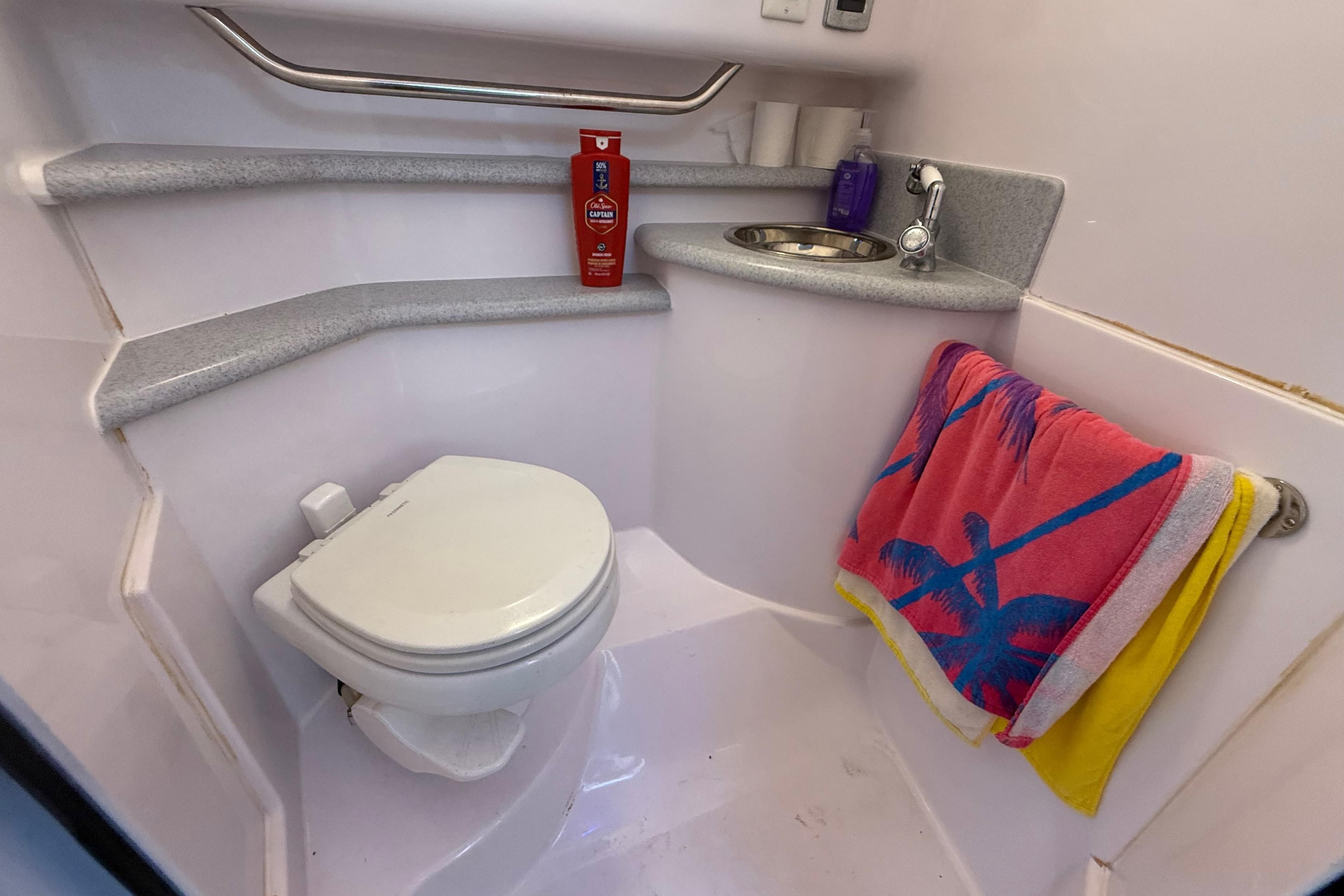 Compact bathroom in 2017 Fountain 38 Sportfish Cruiser with toilet, sink, and colorful towel.