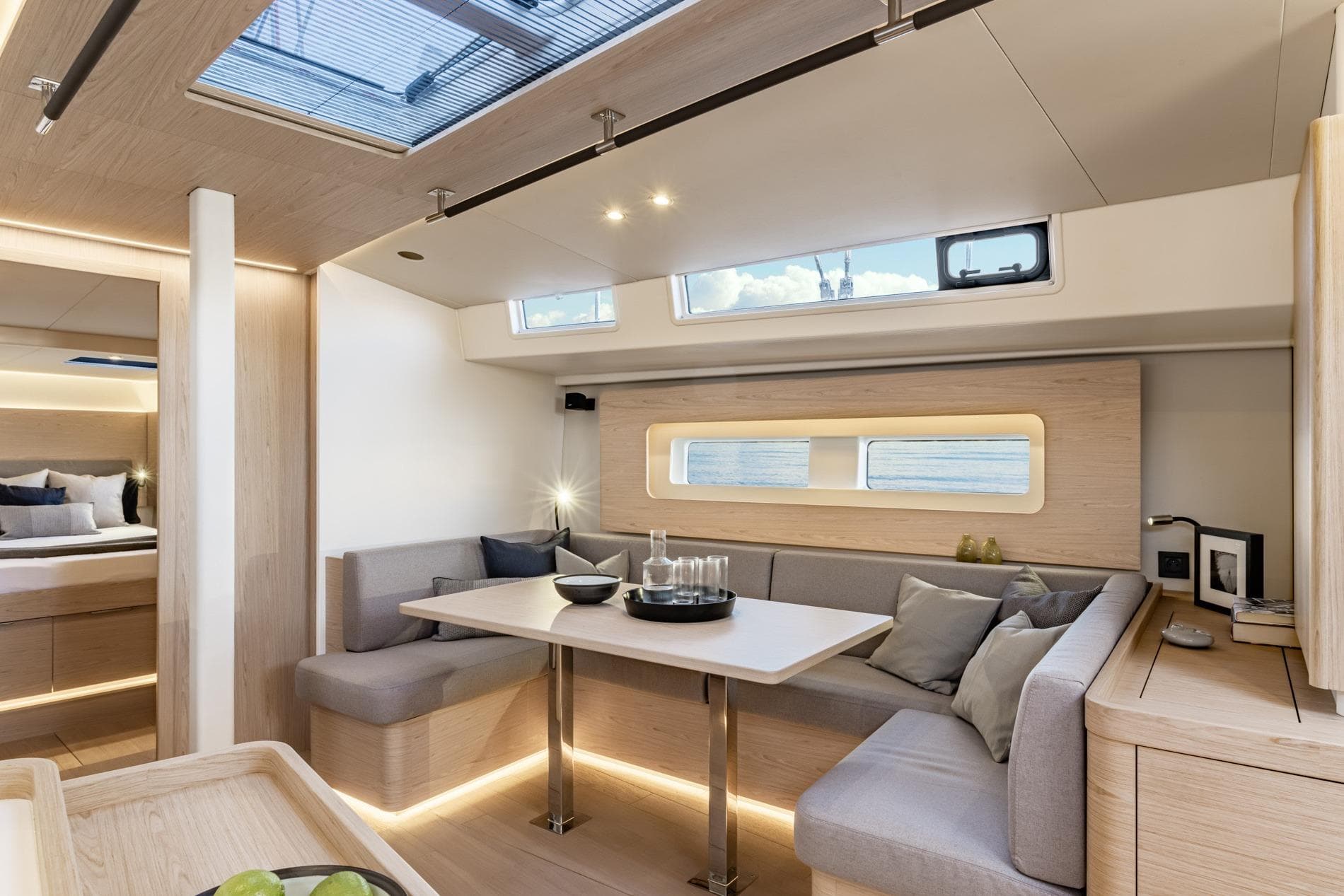 Luxurious interior of 2026 Beneteau Oceanis Yacht 54 with modern seating and skylight.