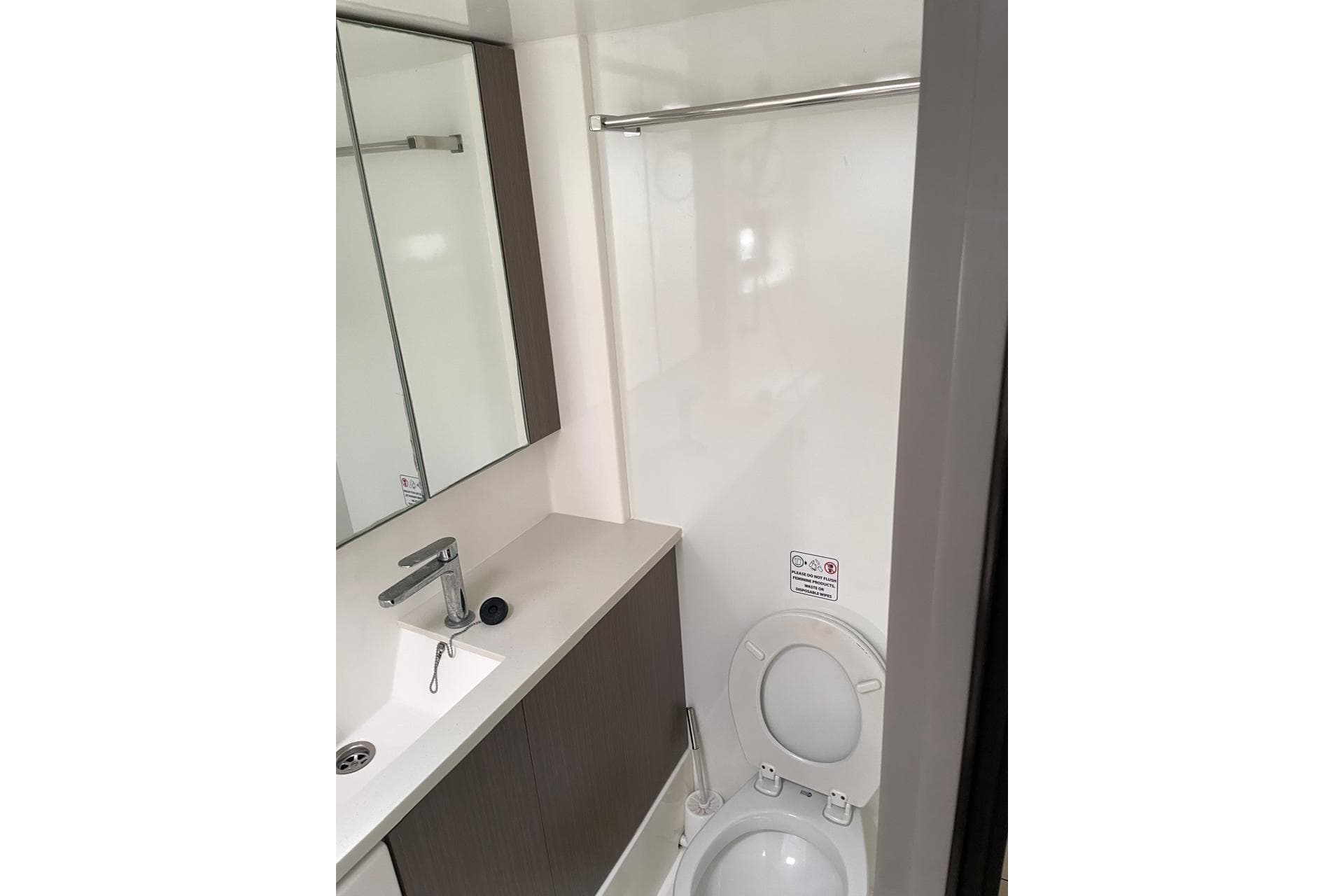 Modern bathroom in 2022 Leopard 45 yacht with sink, mirror, and toilet.