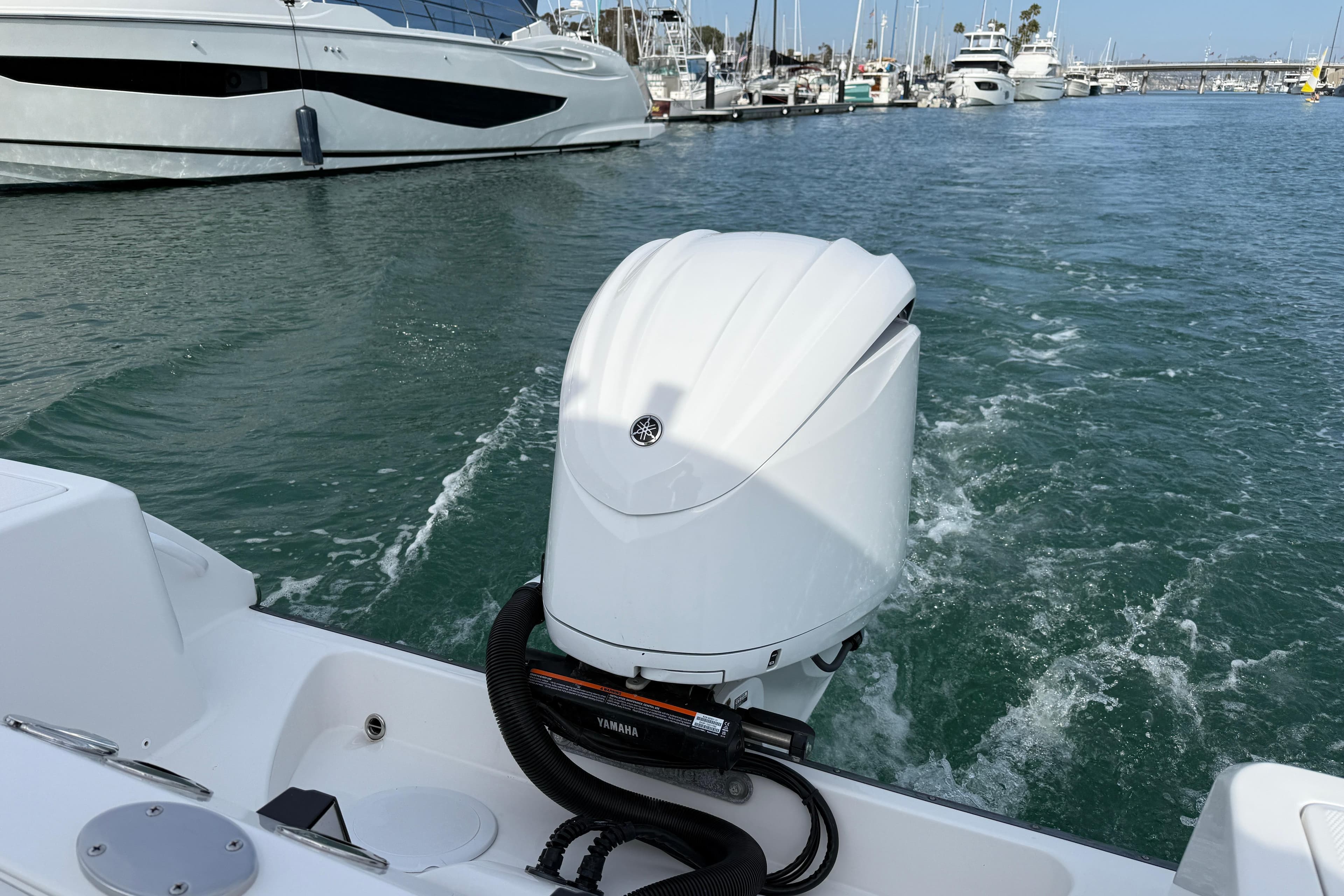 Edgewater 245CC 2023 boat with Yamaha outboard motor in a marina setting.