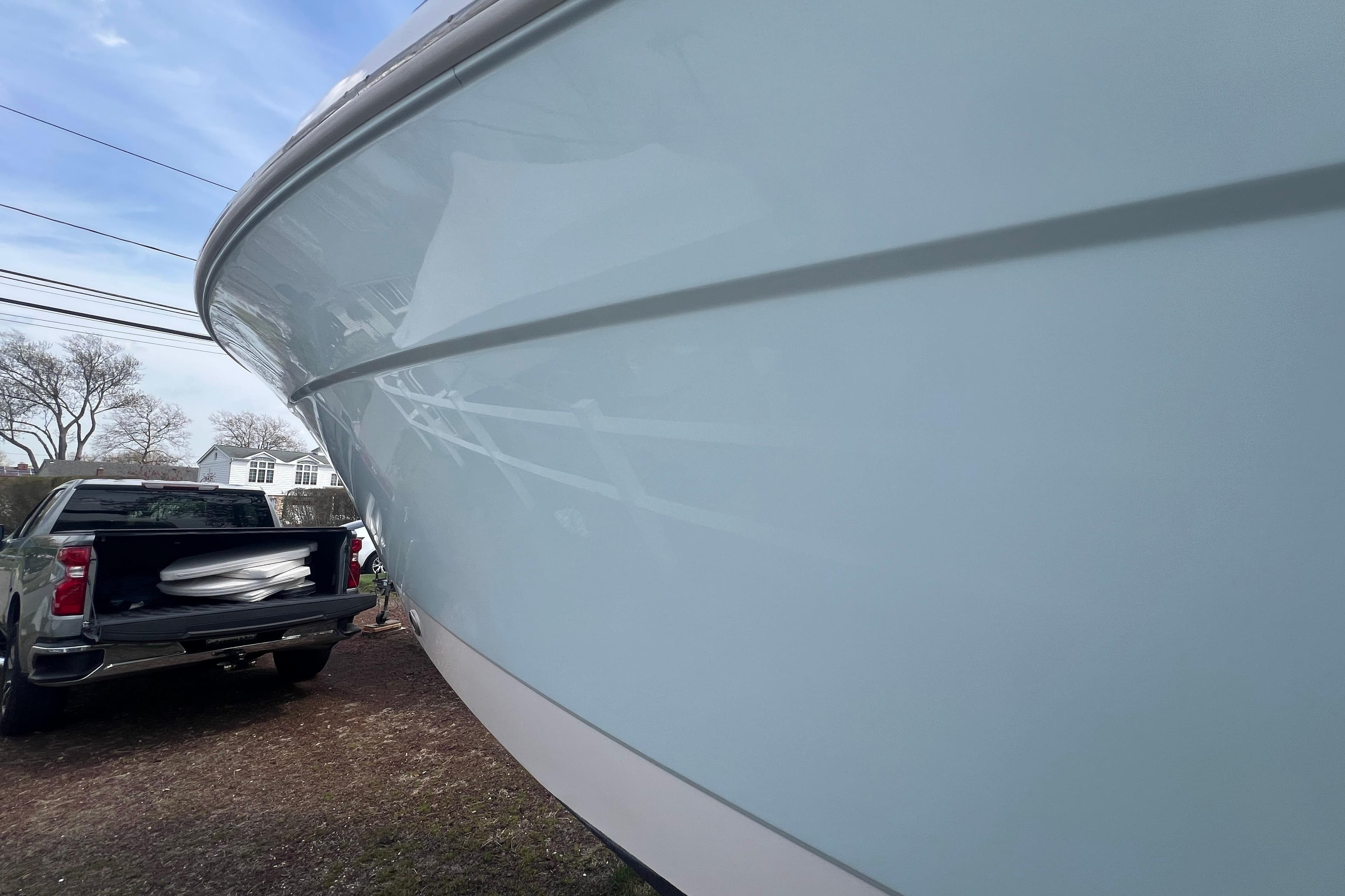 2022 Robalo R227 Dual Console boat beside a parked truck outdoors.