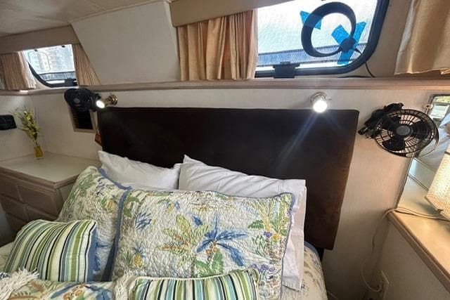 Interior of 1994 Tollycraft 45 Cockpit Motor Yacht with floral bedding and reading lights.