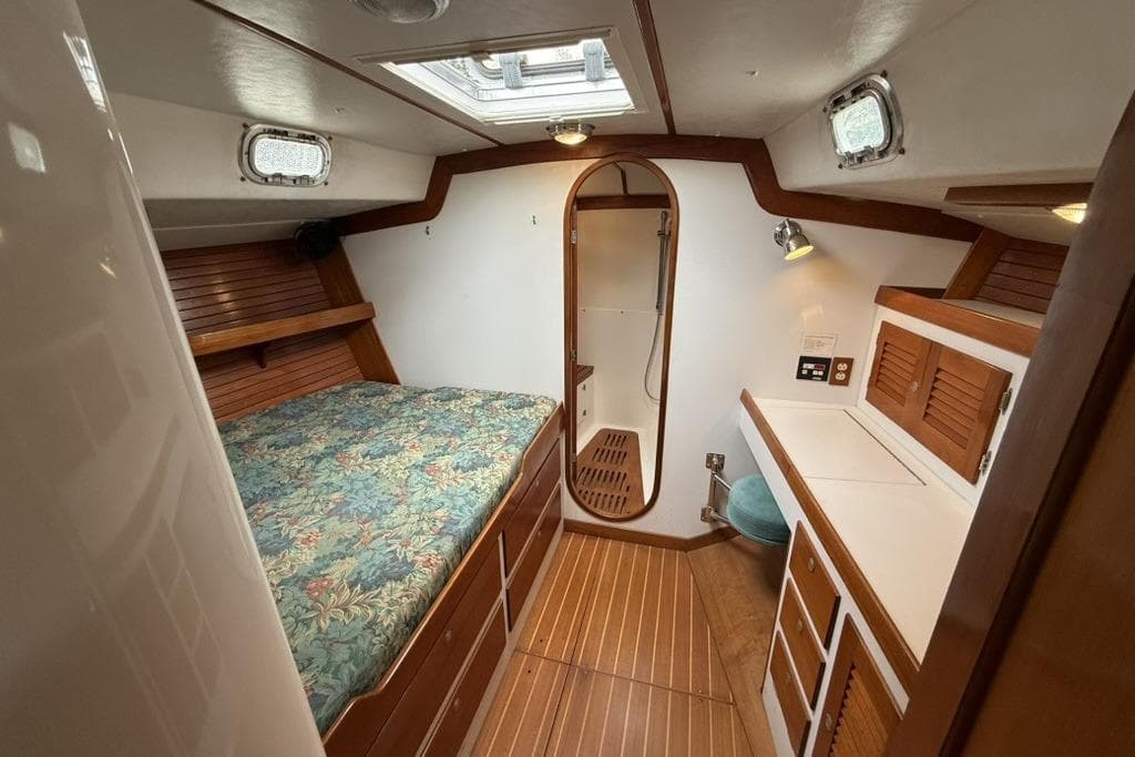 Interior of 1996 J Boats J/160 yacht, featuring a cozy cabin with bed and wooden accents.