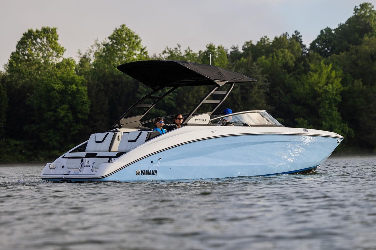 Manufacturer Provided Image: 2026 Yamaha Boats 252SE cruising on a serene lake with lush green trees in the background.