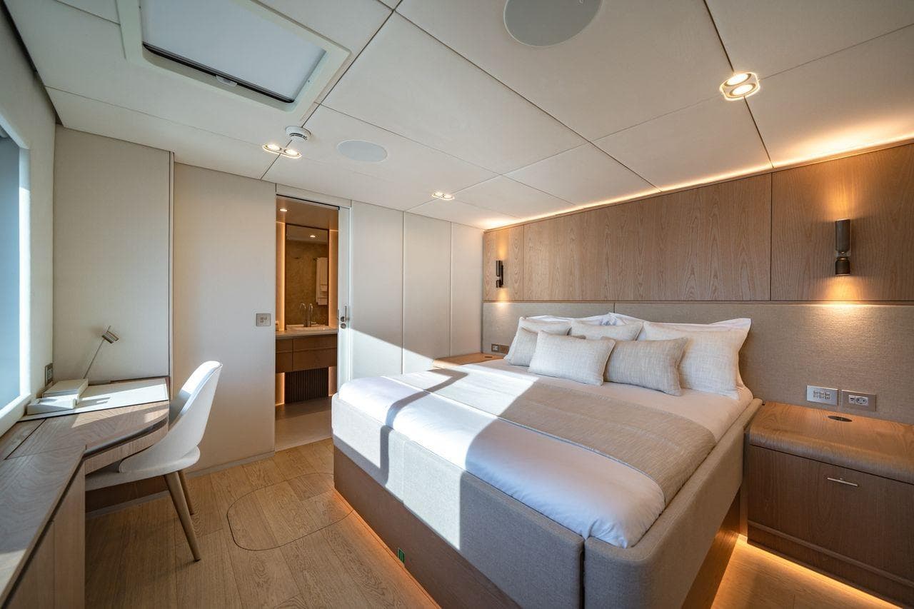Luxurious Sunreef 100 Power 2025 yacht bedroom with modern design and natural lighting.