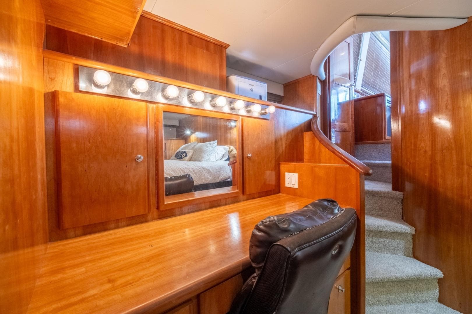 Luxurious wooden interior of 2003 Navigator 5700 yacht with vanity and staircase.