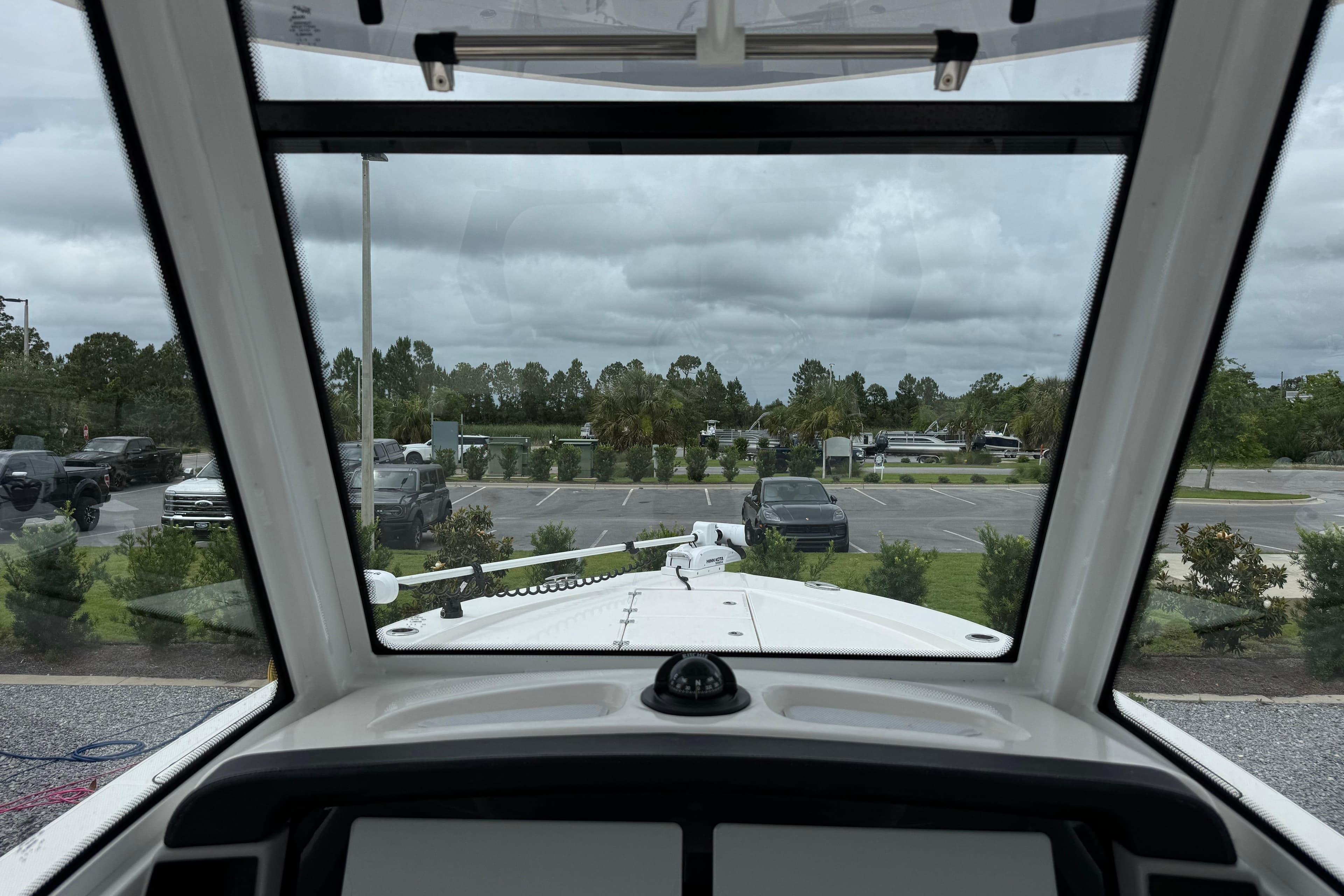 View from inside a 2023 Robalo 266 Cayman boat, overlooking a parking lot.