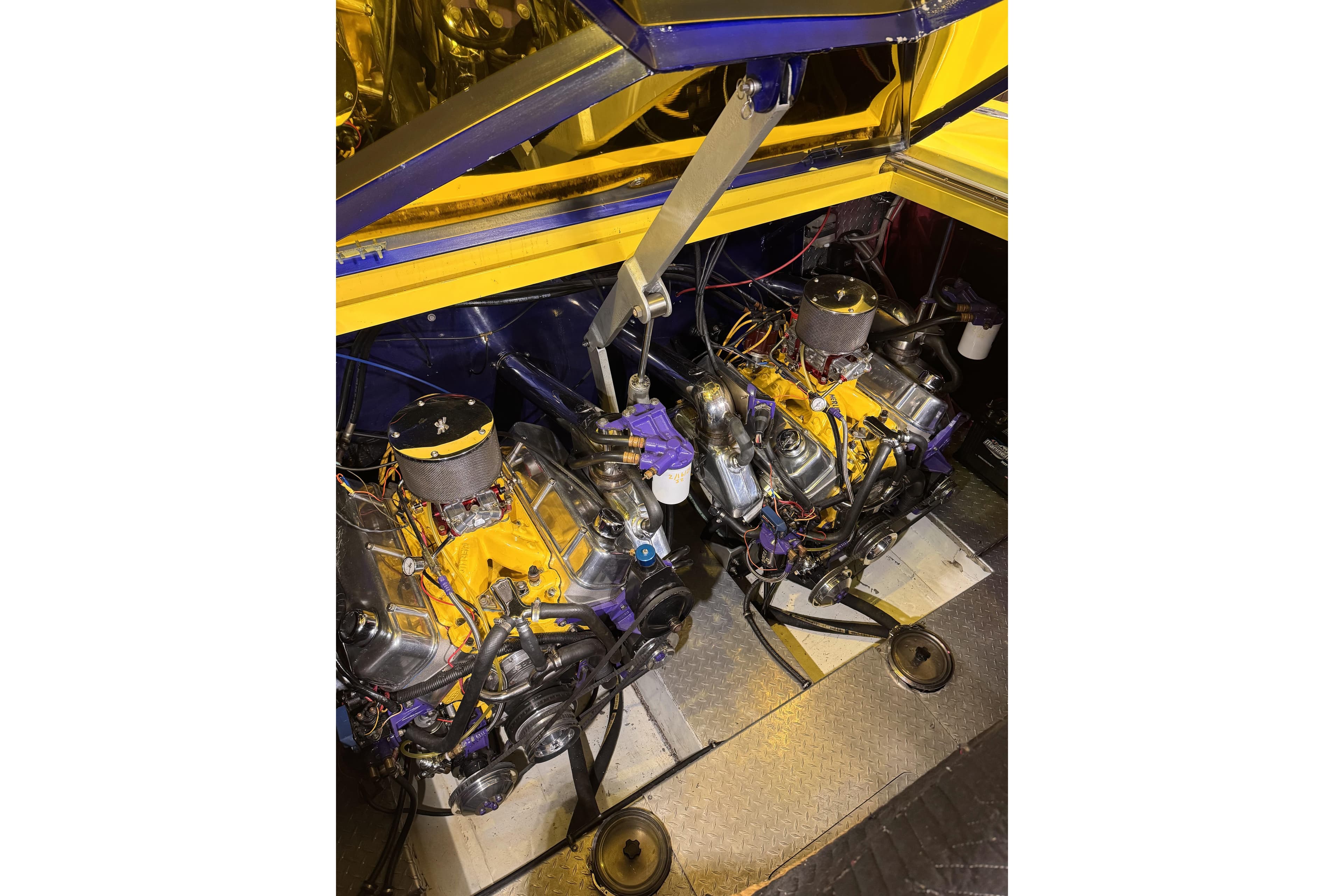 Engine compartment of a 2000 Python Offshore boat, showcasing dual engines and vibrant yellow accents.