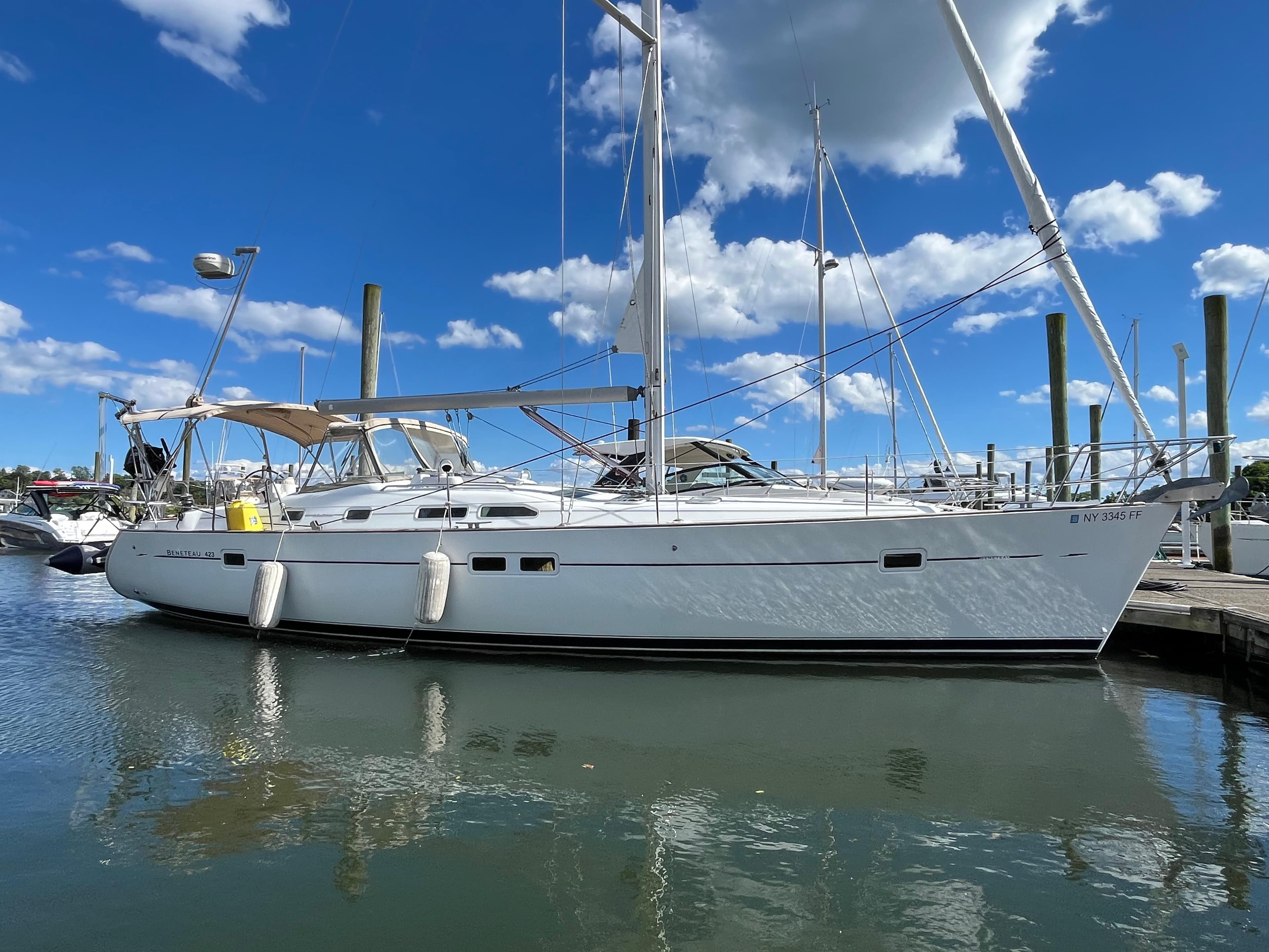 2004 Beneteau 423 sailboat docked under blue sky.
