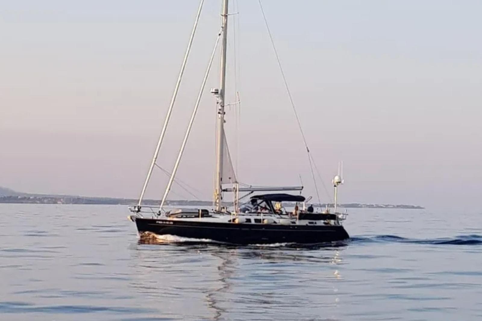 Sailing yacht Moody 47, 2002 model, cruising on calm waters at sunset.