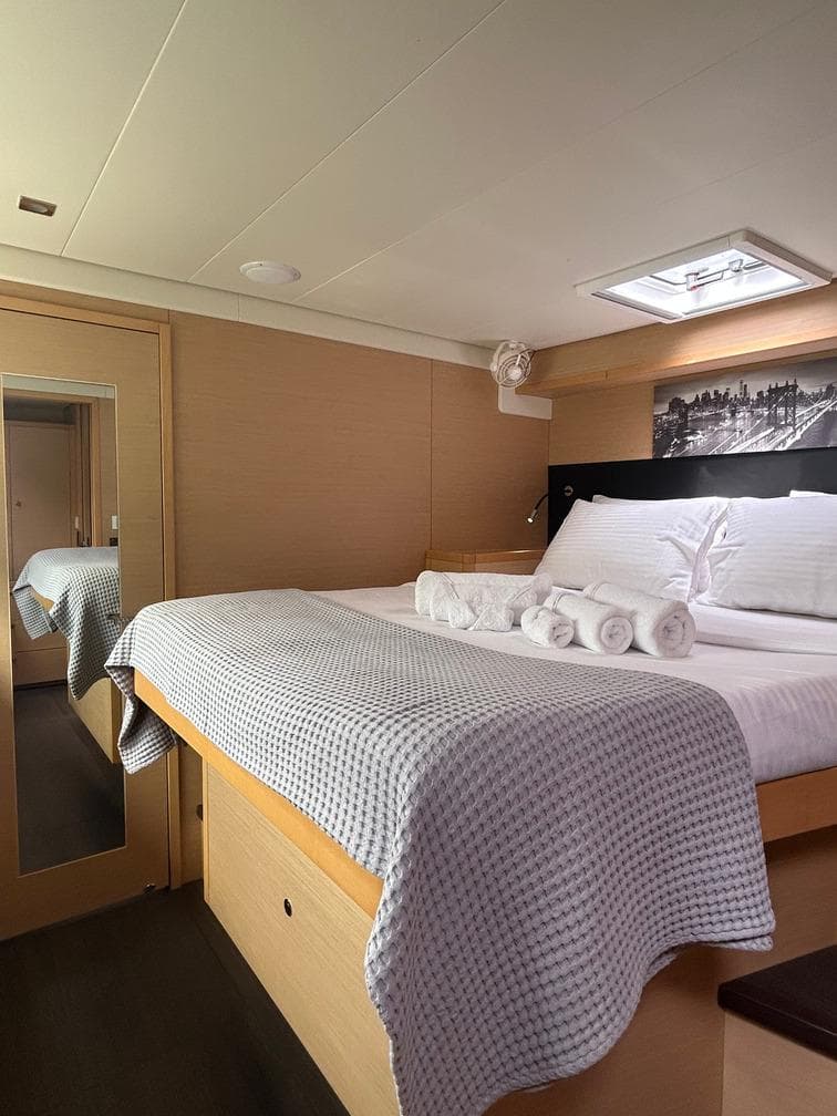 Luxurious cabin interior of 2013 Lagoon 52 yacht with cozy bedding and elegant decor.