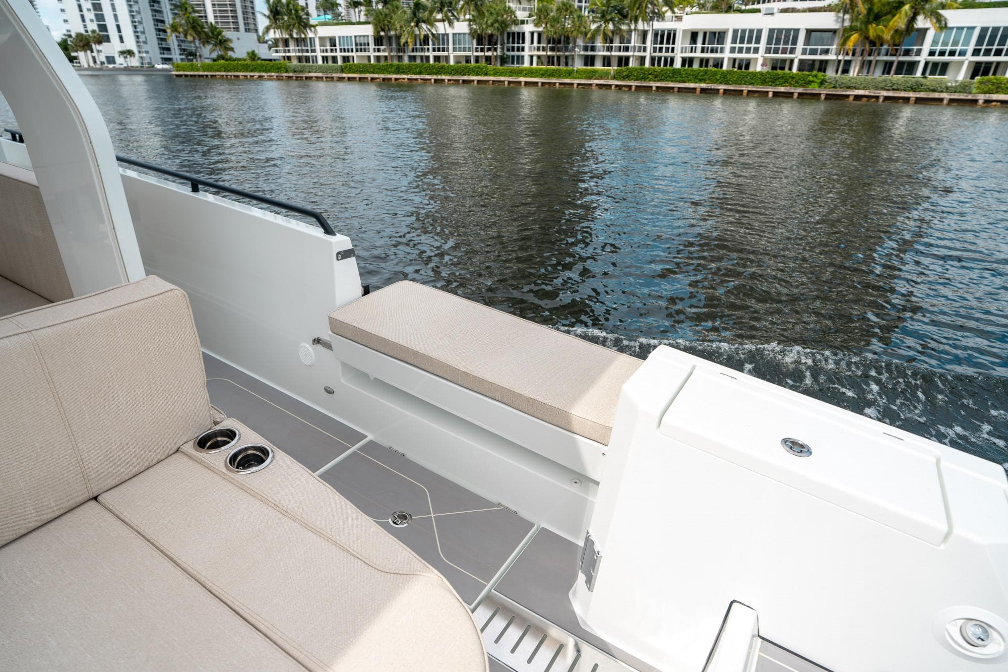 2025 Quarken 35 Sport Tourer boat interior with beige seating, cup holders, and waterfront view.