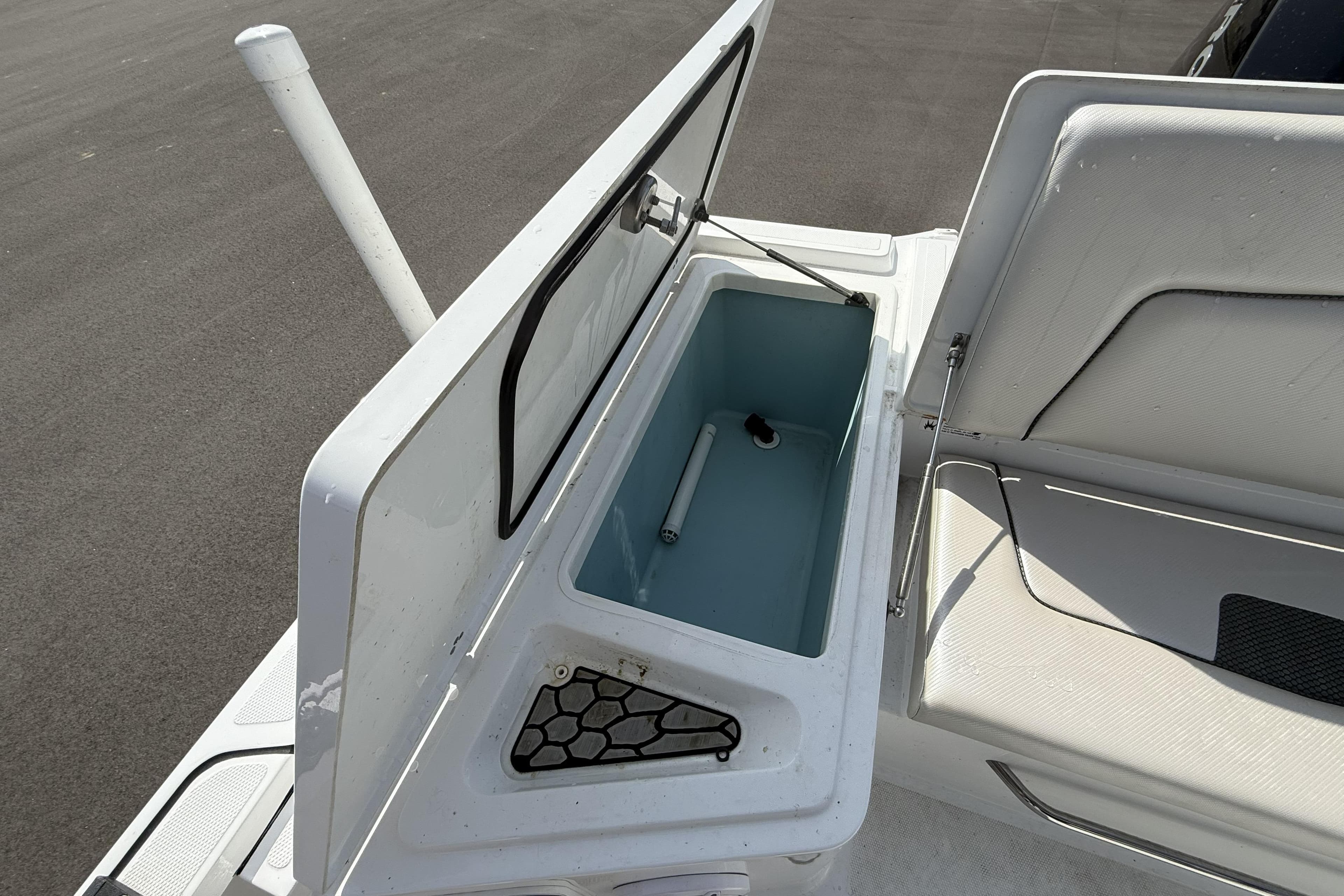 Open storage compartment on a 2019 Wellcraft 221 Bay boat, showcasing interior space.