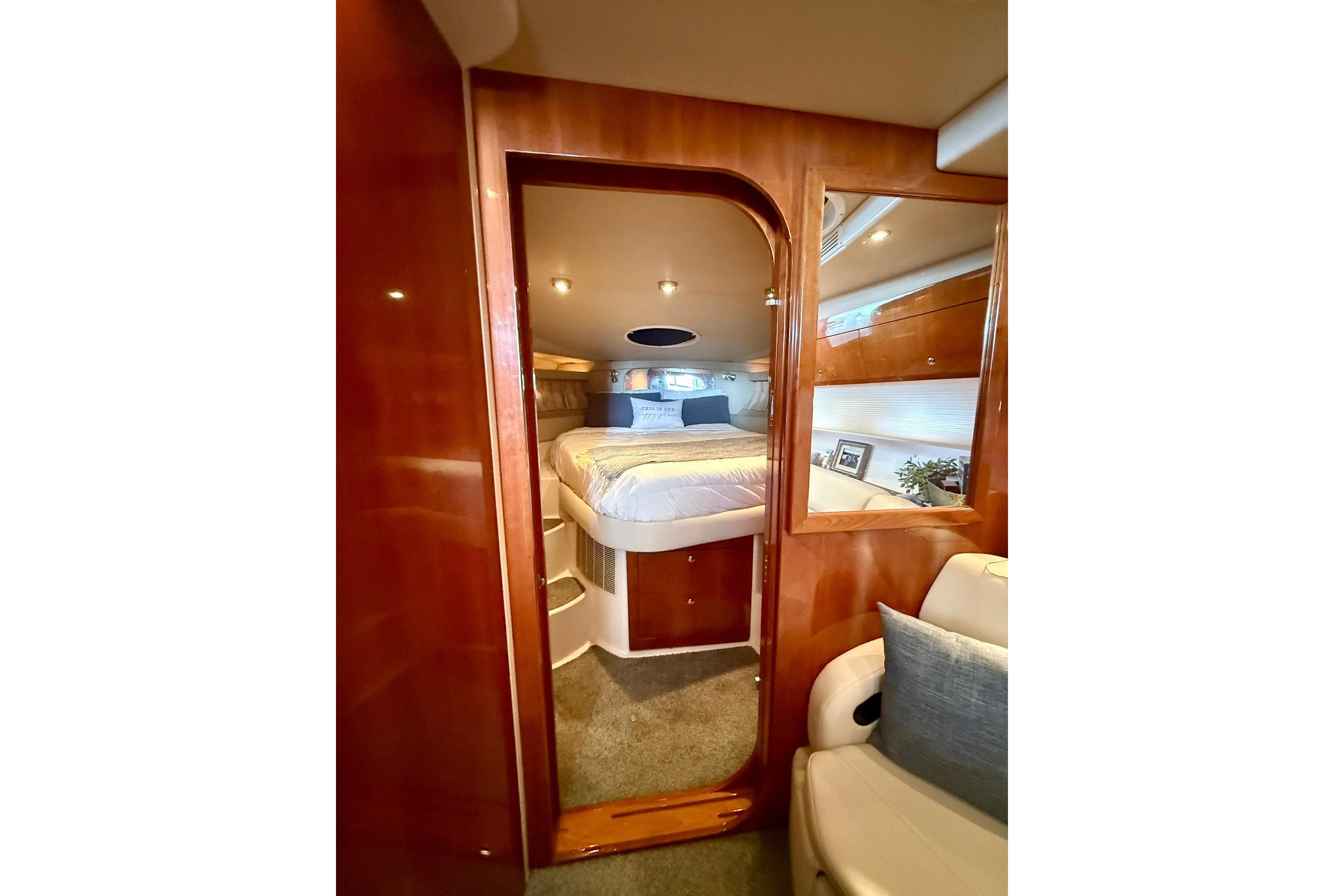 Luxurious cabin interior of 2006 Regal Commodore 4060 yacht with cozy bed and wooden finish.