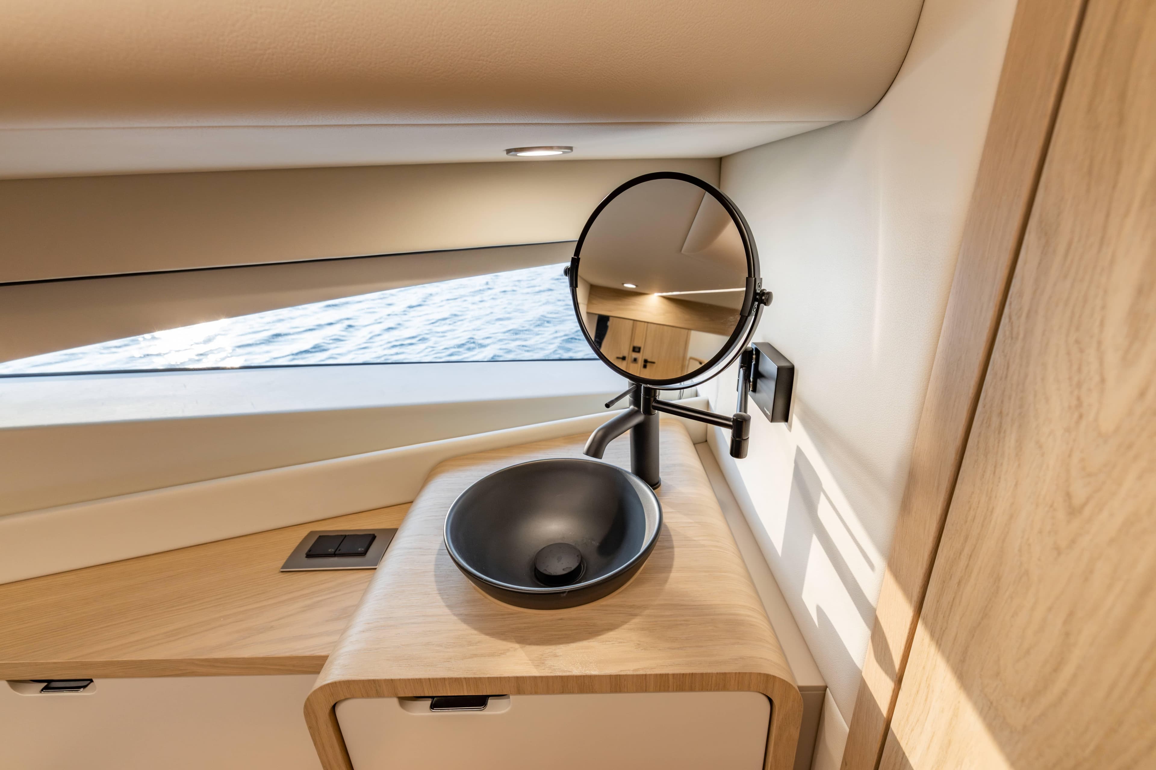 Luxurious bathroom interior of 2025 Steeler Bronson 65 yacht with modern sink and mirror.