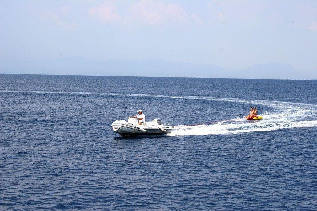 Akerboom Lisse 1958 boat towing inflatable on open sea.