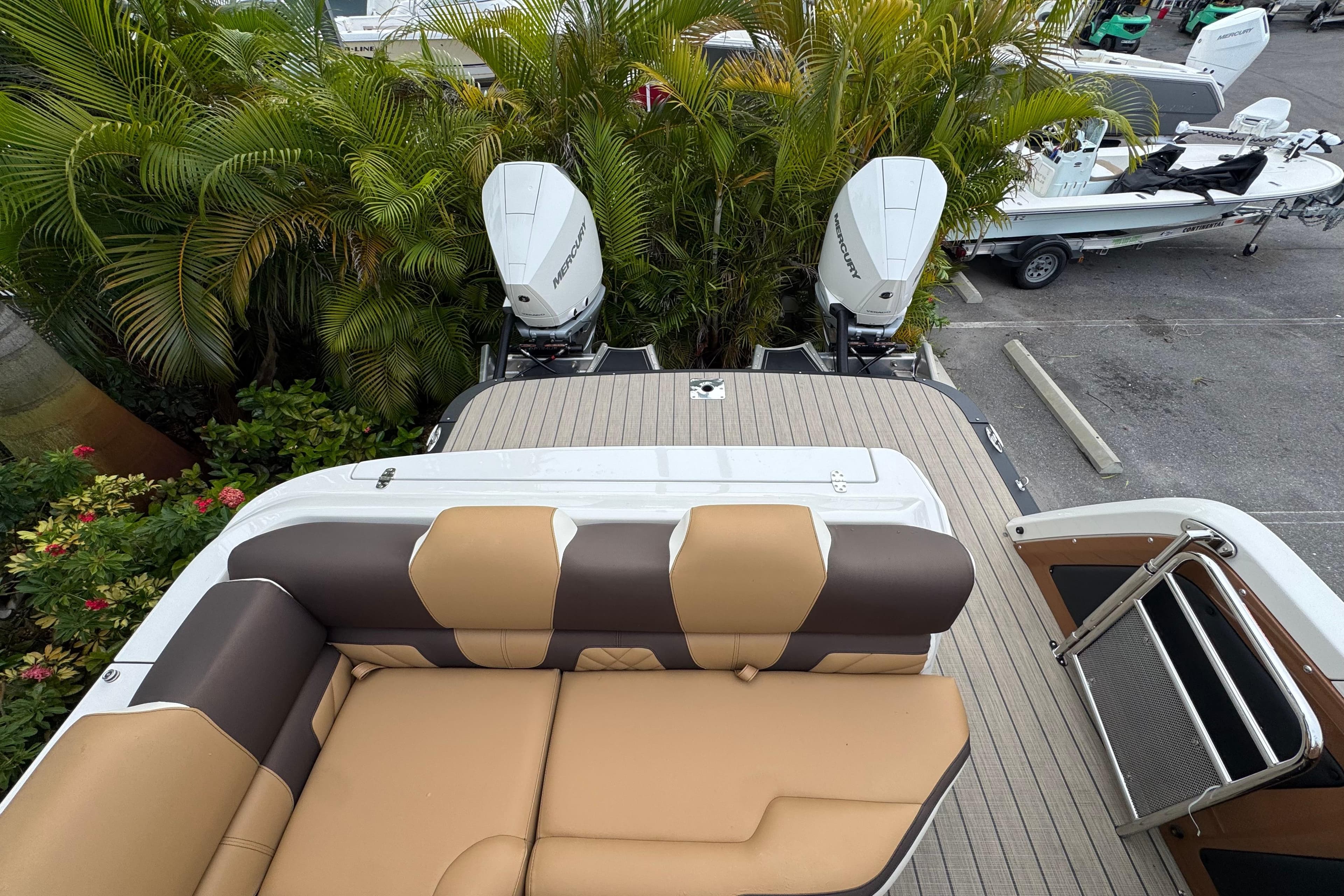 2026 Avalon Excalibur 27' boat with tan seating and dual Mercury outboard engines.