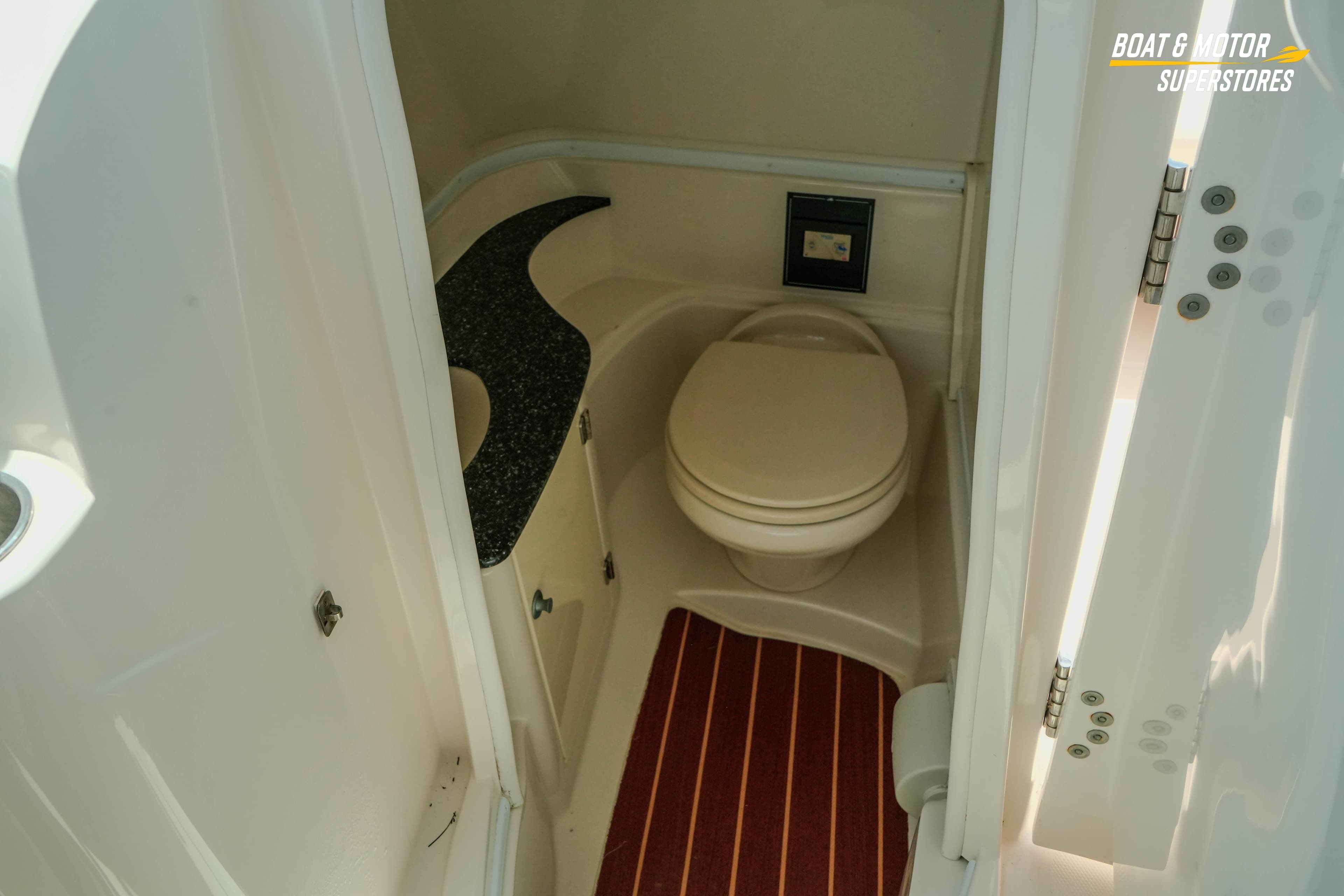 2012 Monterey 264FS boat bathroom with compact toilet and sleek countertop design.