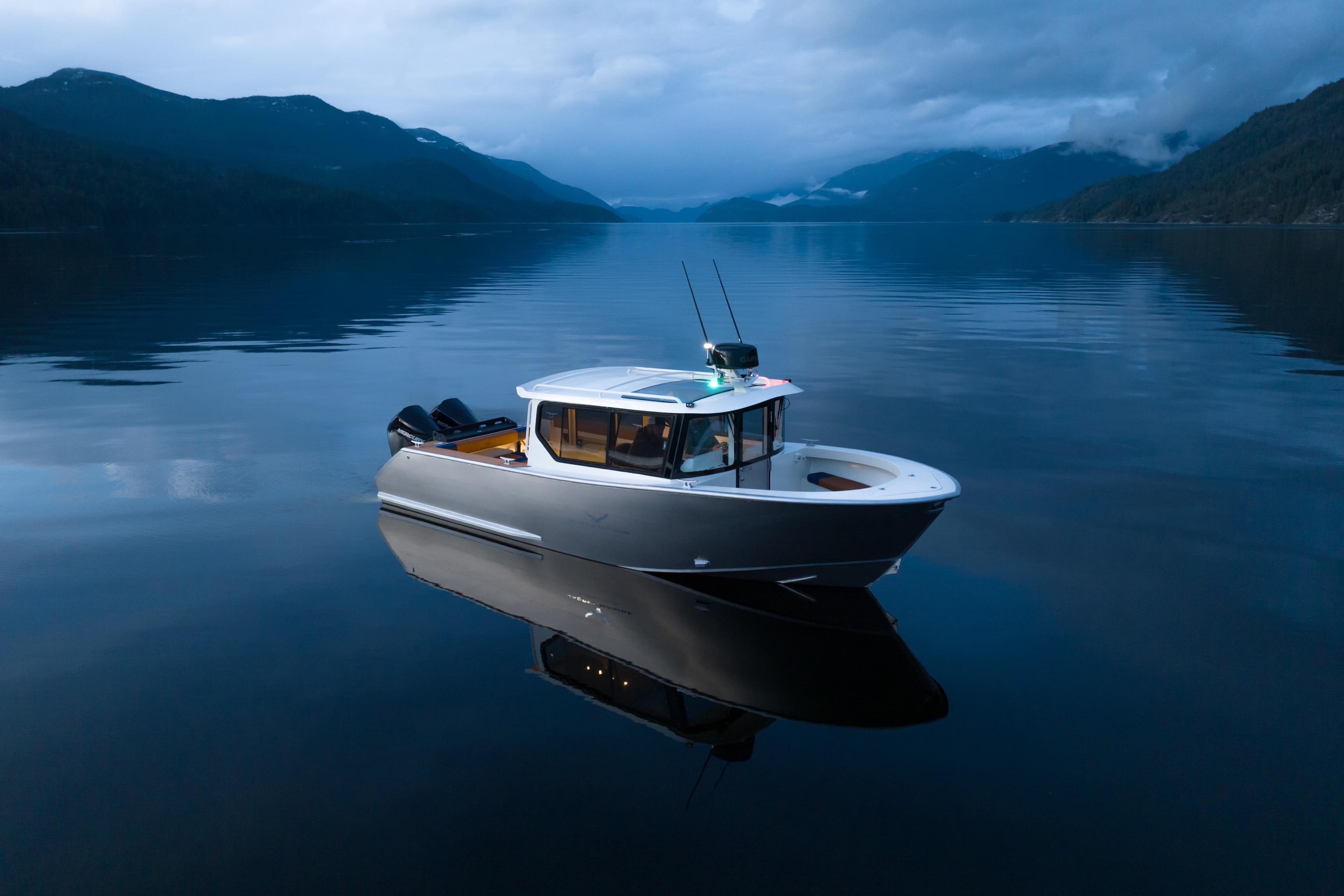 2026 Jasper Marine Defender 22 boat on serene lake with mountainous backdrop.