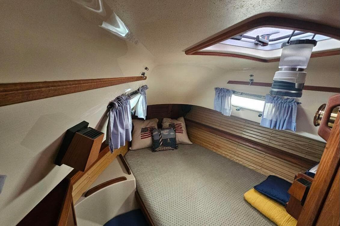 Cozy cabin interior of 1999 Island Packet 350 sailboat with nautical decor and soft lighting.
