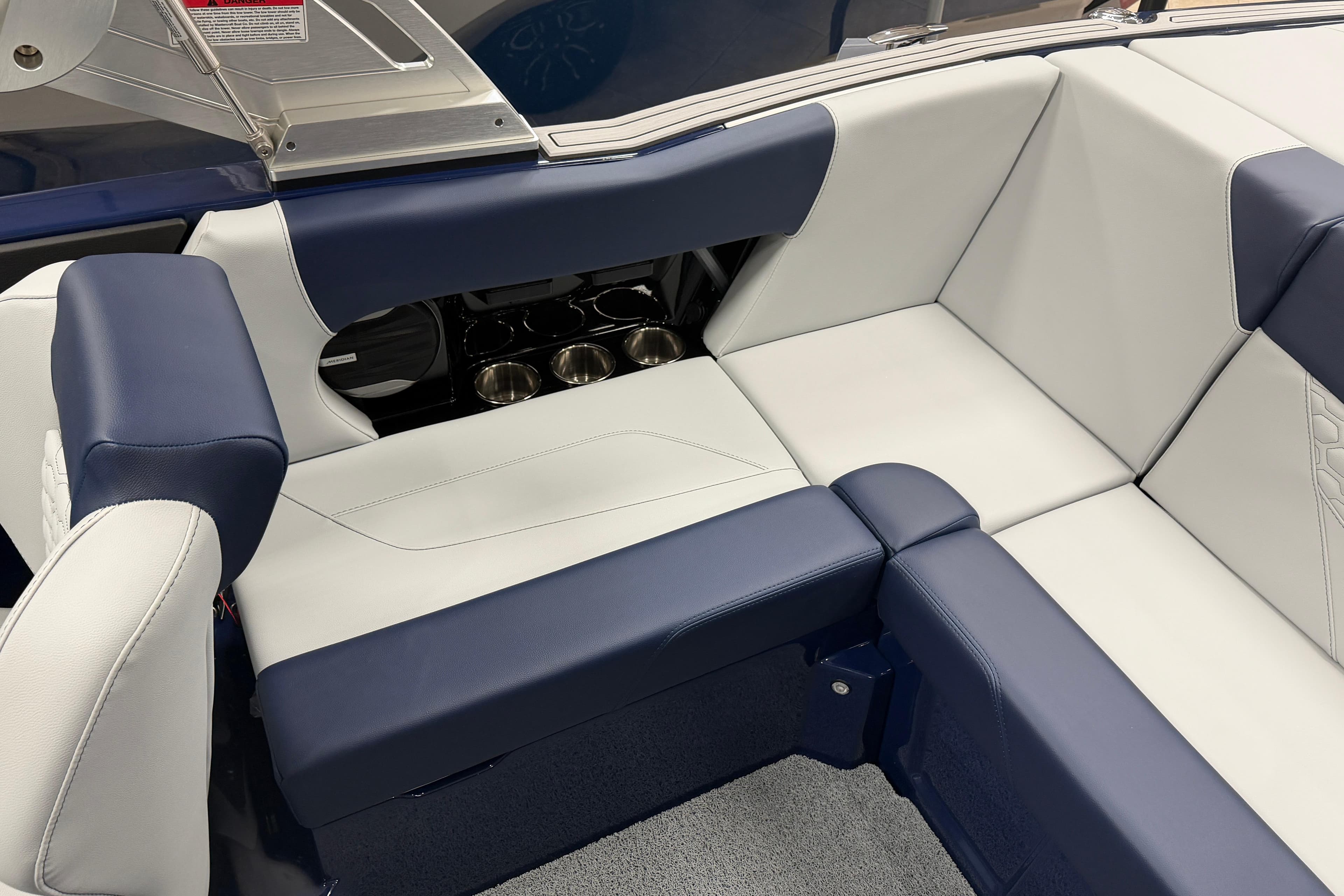 2026 MasterCraft NXT20 boat interior with blue and white seating and cup holders.