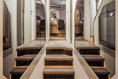 Luxurious yacht interior with elegant stairs, modern design, and ambient lighting, Absolute Fly Co Ownership 2023.