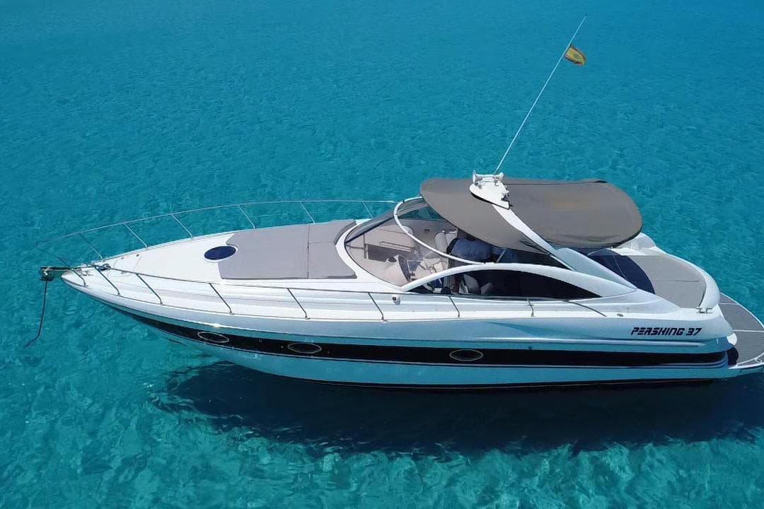 2002 Pershing 37 yacht on clear turquoise water, showcasing sleek design and luxury.