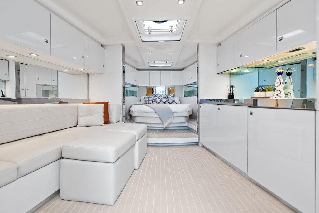 Luxurious interior of a 2015 VanDutch 55 yacht with modern white furnishings.
