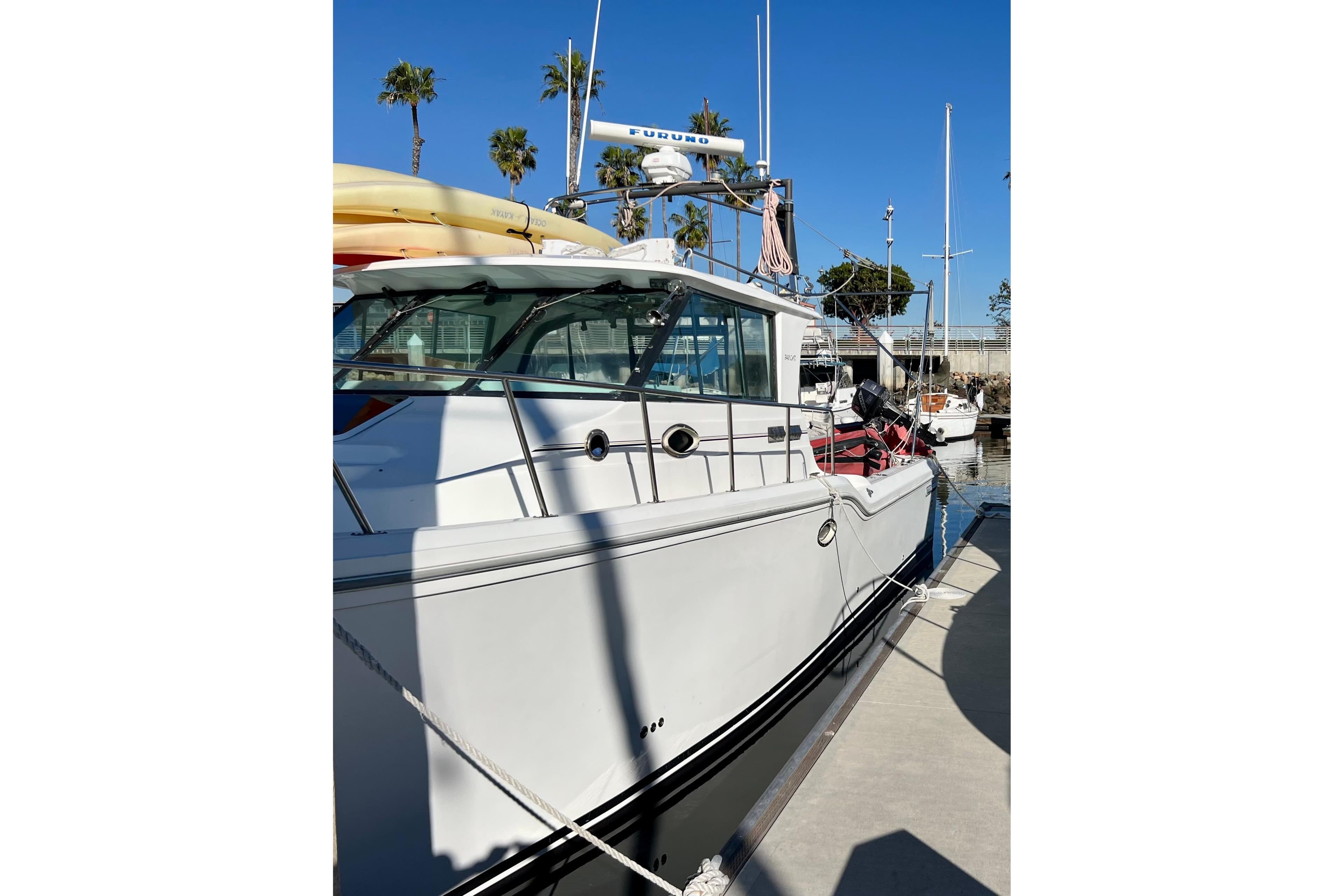 1998 Baha Cruisers 340 CAT docked, featuring sleek design and sunny marina backdrop.