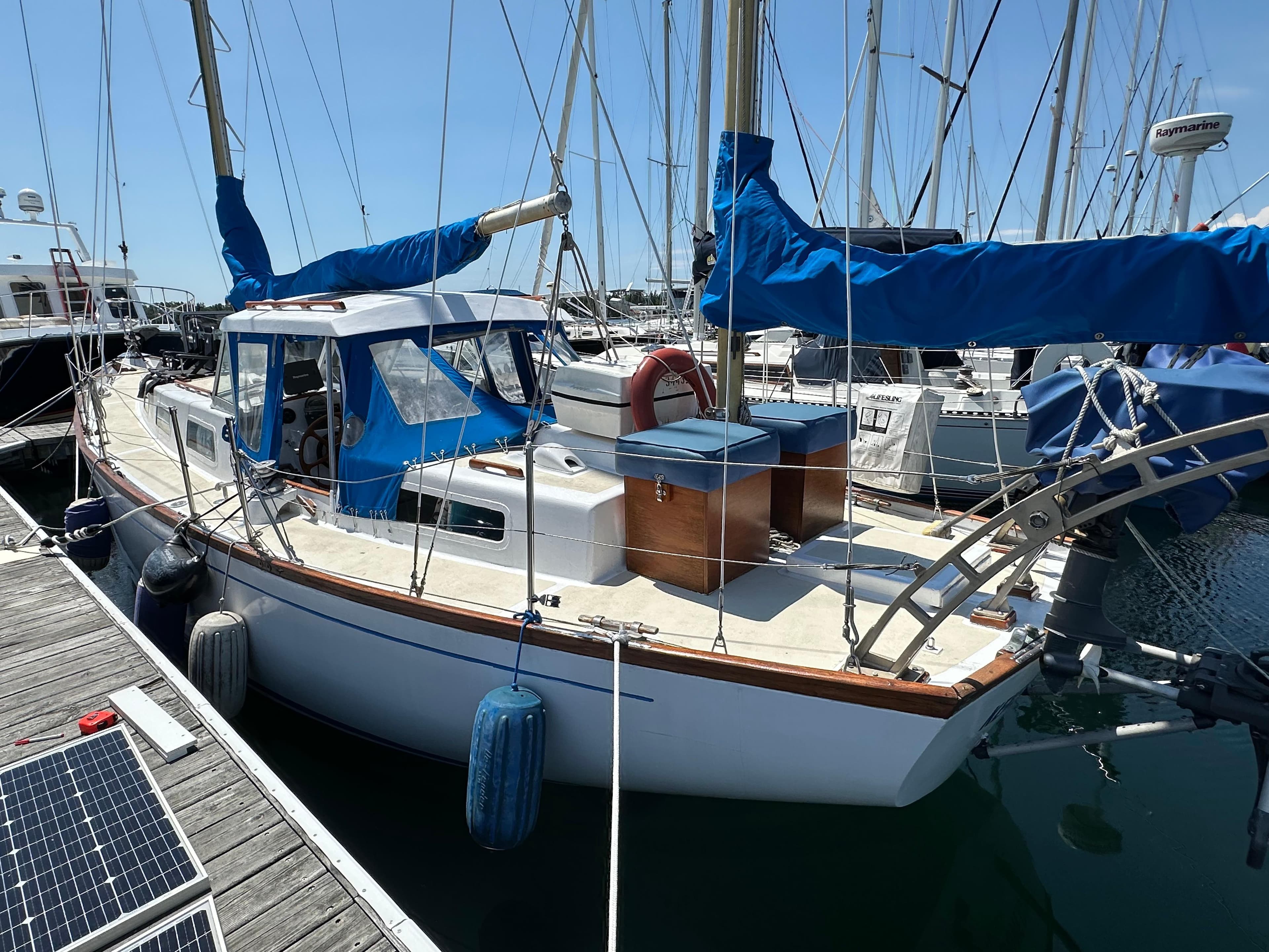 1968 Camper & Nicholsons 38 Ketch sailboat docked at marina, blue covers, classic design.