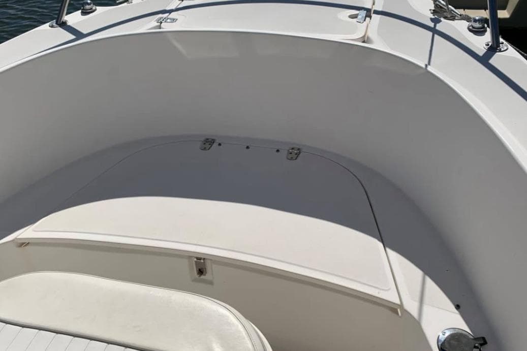 1999 Boston Whaler 21 Outrage boat interior, featuring white seating and storage compartment.