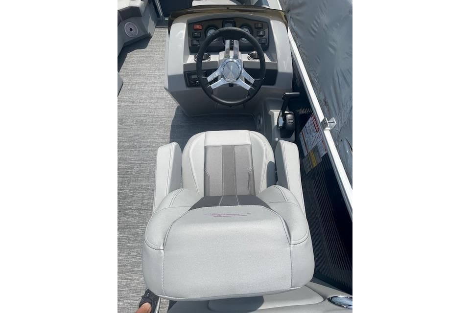 2024 Bennington 22SXSR boat helm with steering wheel and captain's chair.