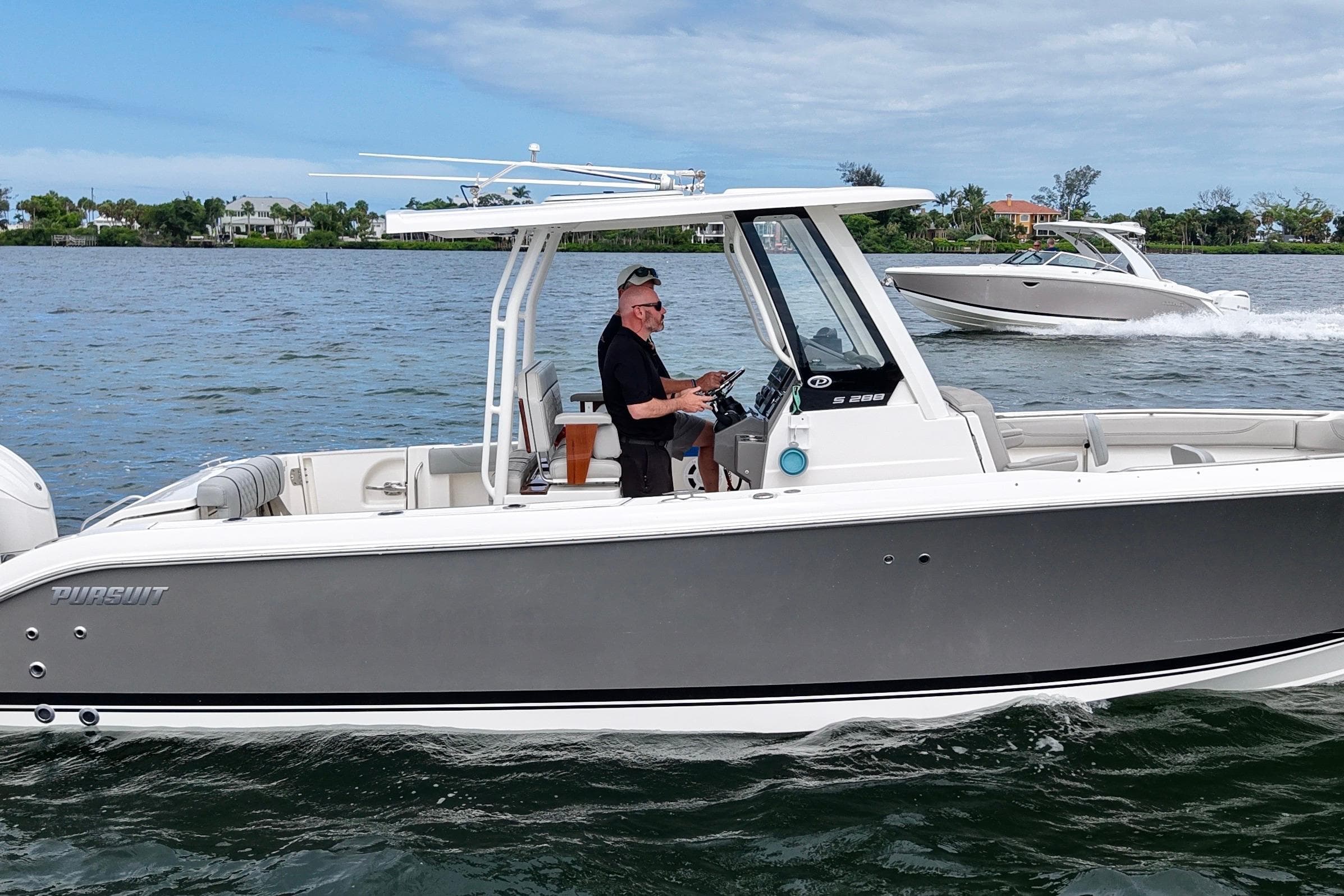 2022 Pursuit S 288 Sport boat cruising on a scenic waterway.