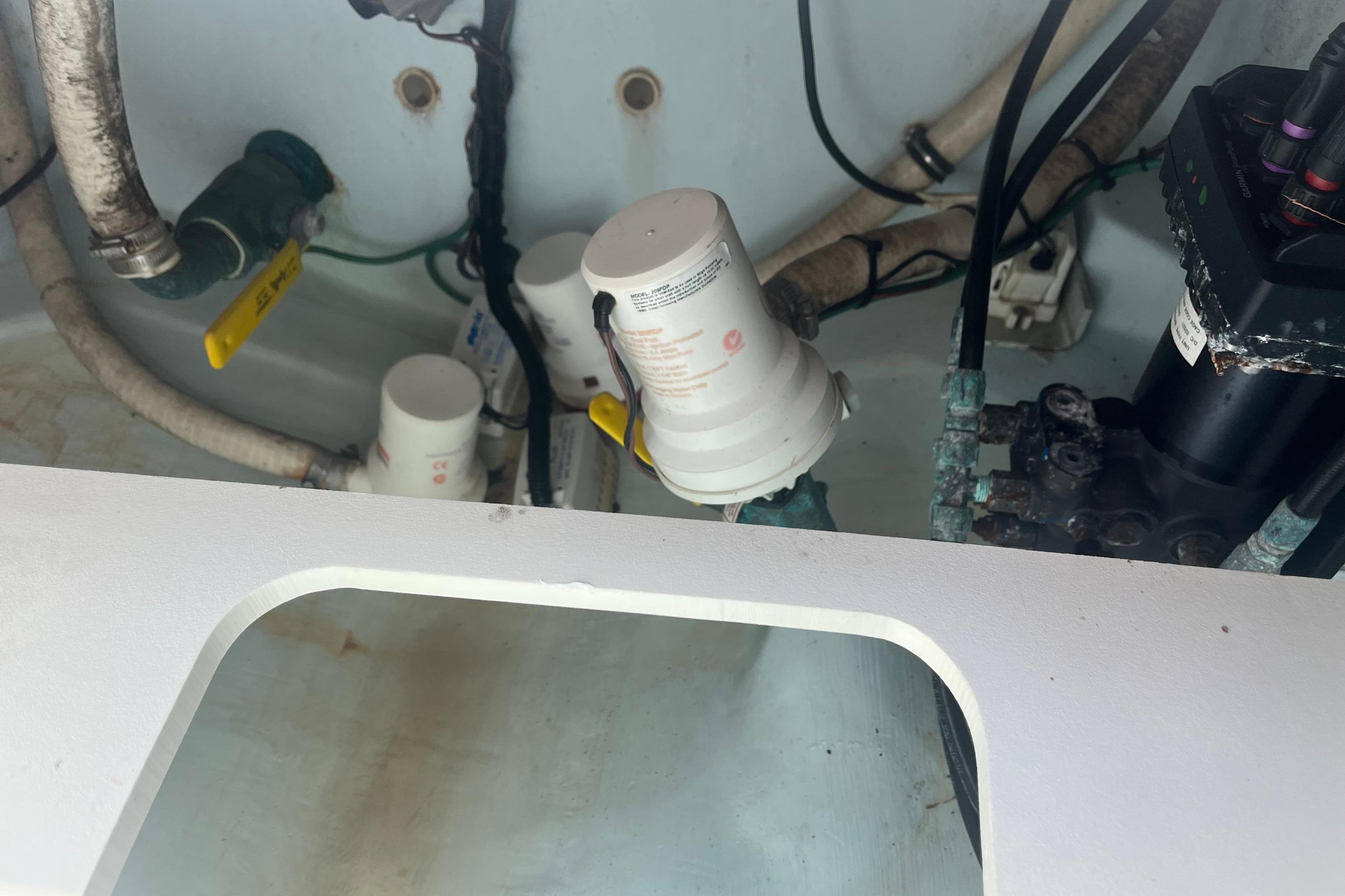Engine compartment of a 2015 Jupiter 26 FS boat, showing hoses and filters.