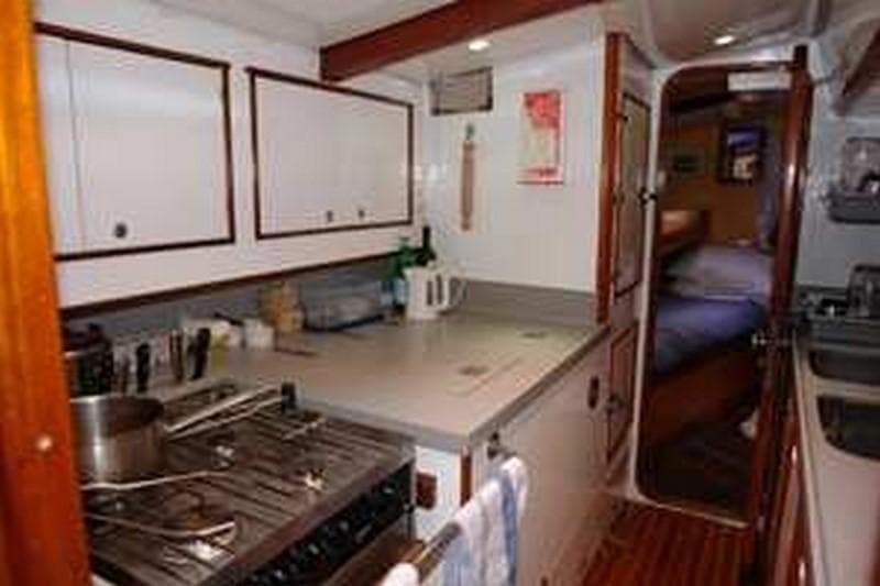 Interior of 1980 Ketch Presles 72 yacht kitchen with stove and cabinets.